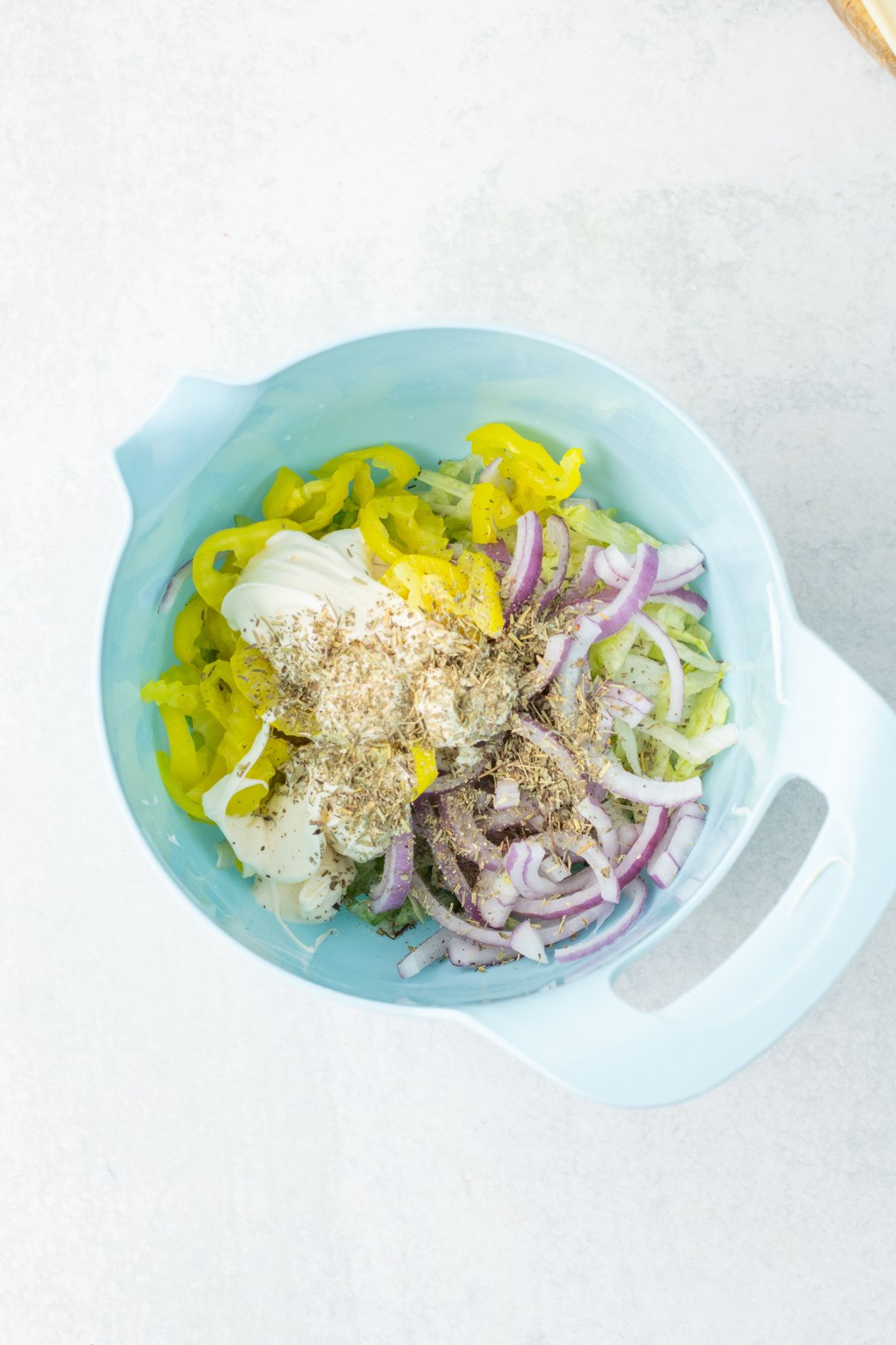 Mayo, onion, lettuce, and italian seasoning in a bowl.