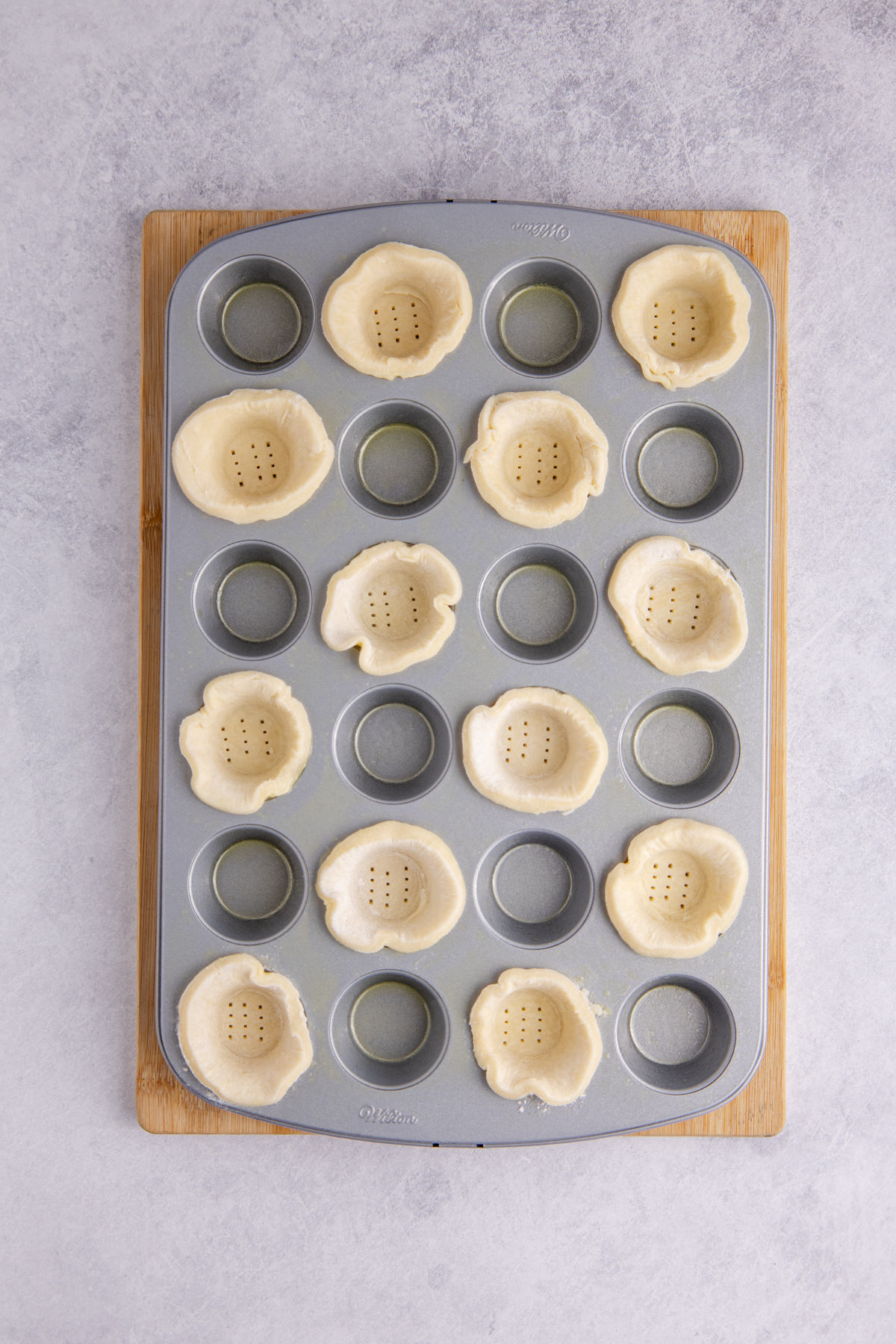 Each round placed into the muffin tin, shaping it up the sides.