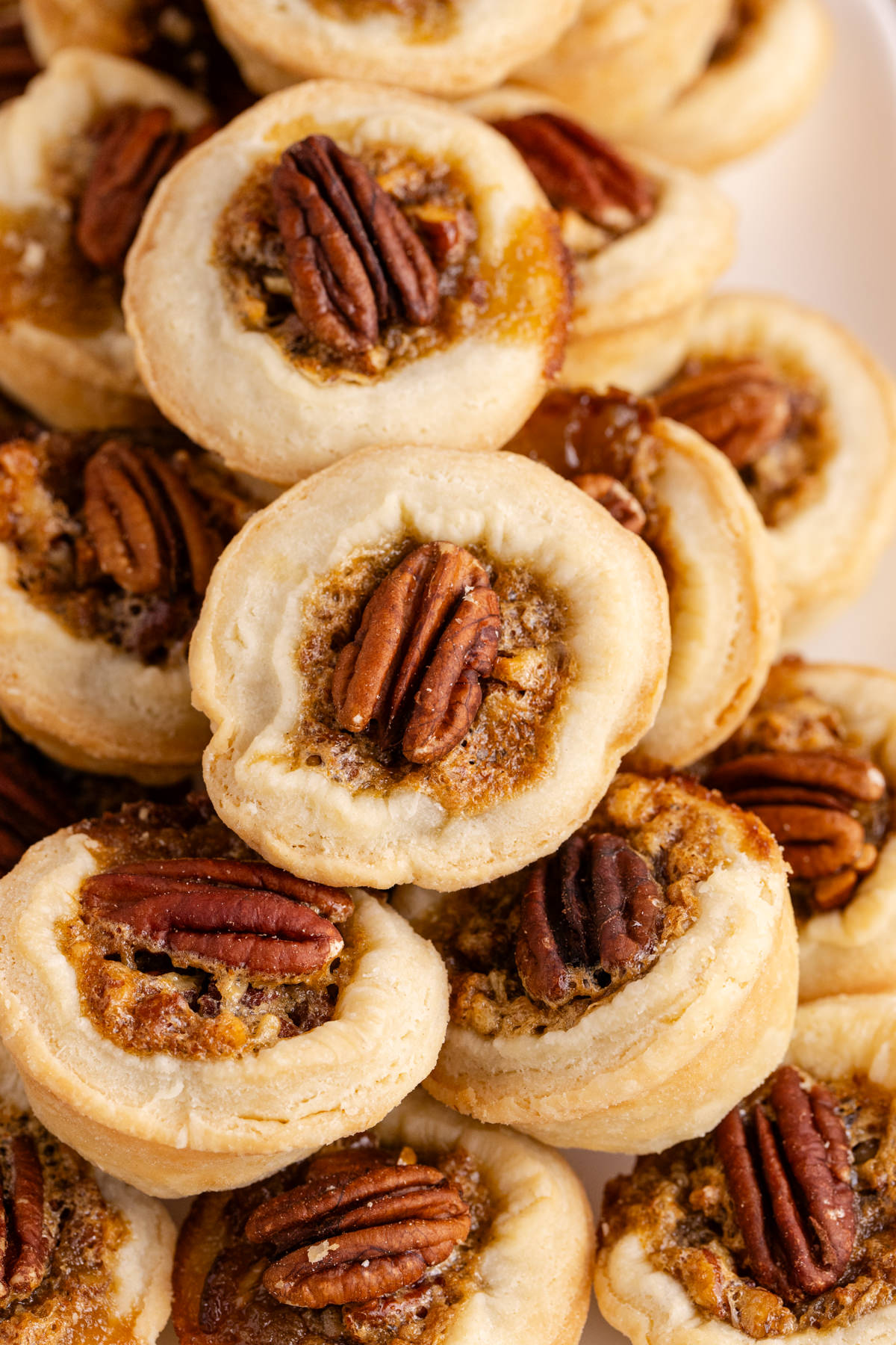 A stack of tarts with pecans in the center.