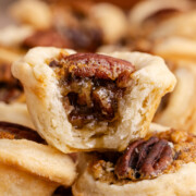 Mini pecan tarts stacked on top of other tarts.