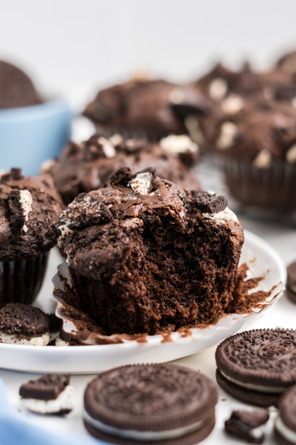 A muffin with oreos in it with a bite taken out.