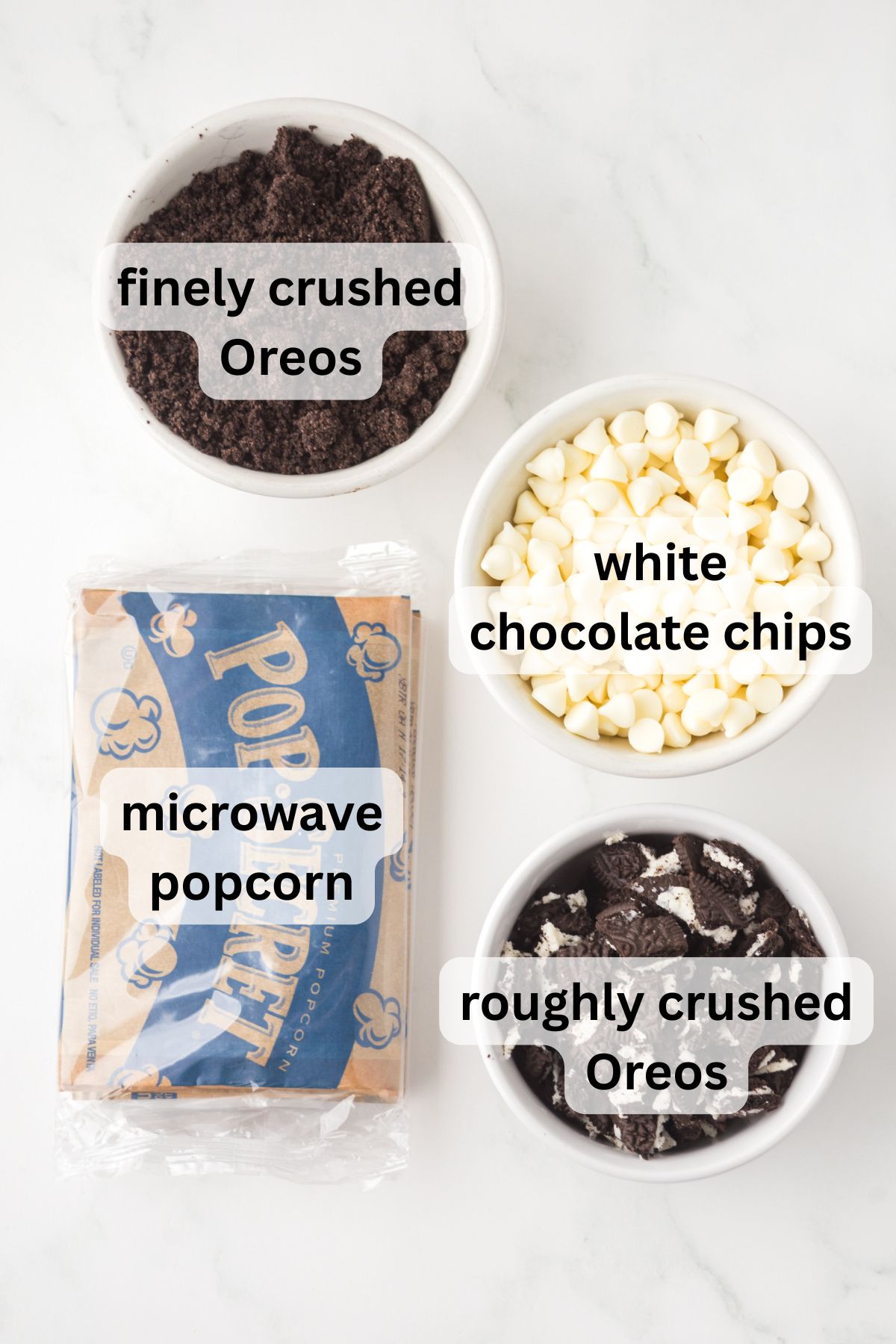 All of the ingredients needed to make Oreo popcorn in bowls on a table.
