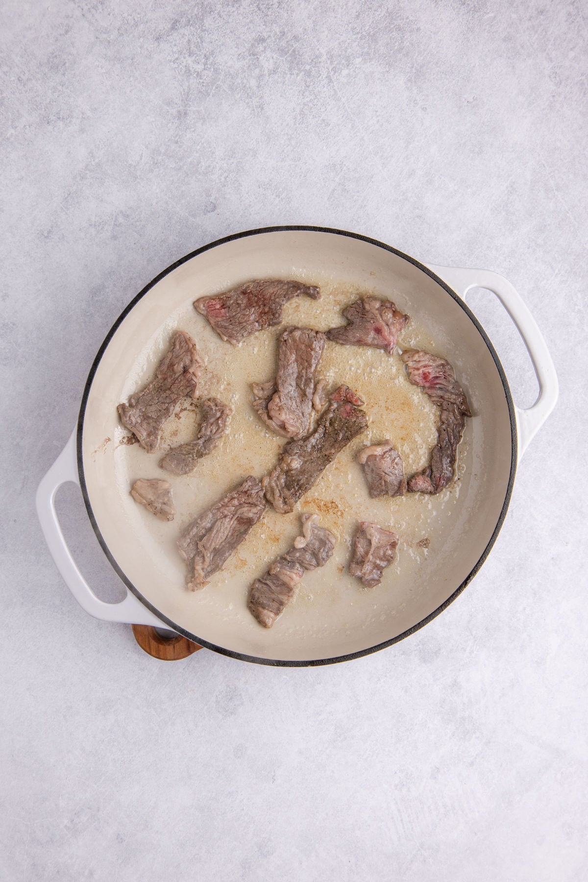 Meat searing in a skillet.