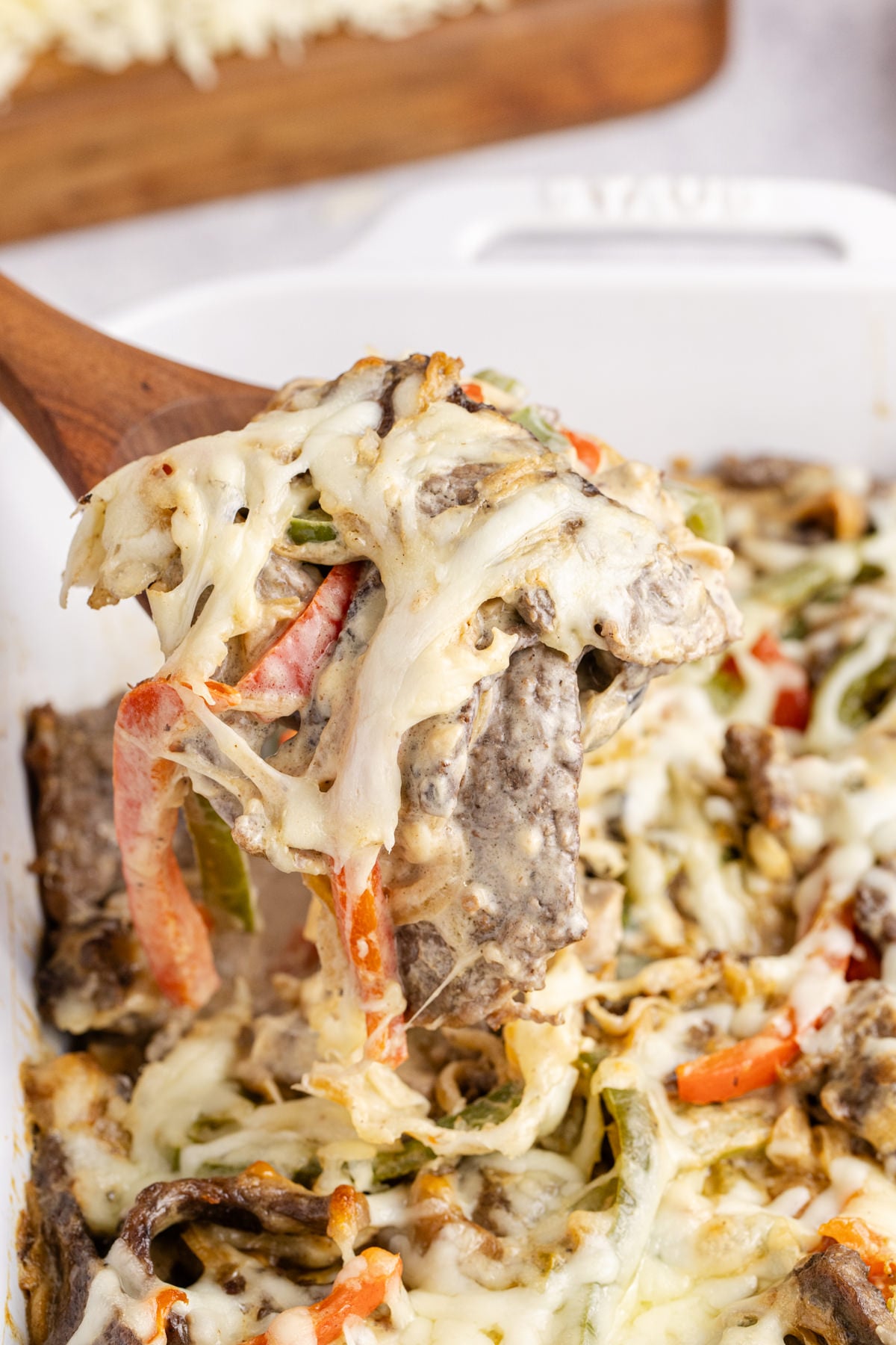Cheesesteak casserole on a wooden spoon.