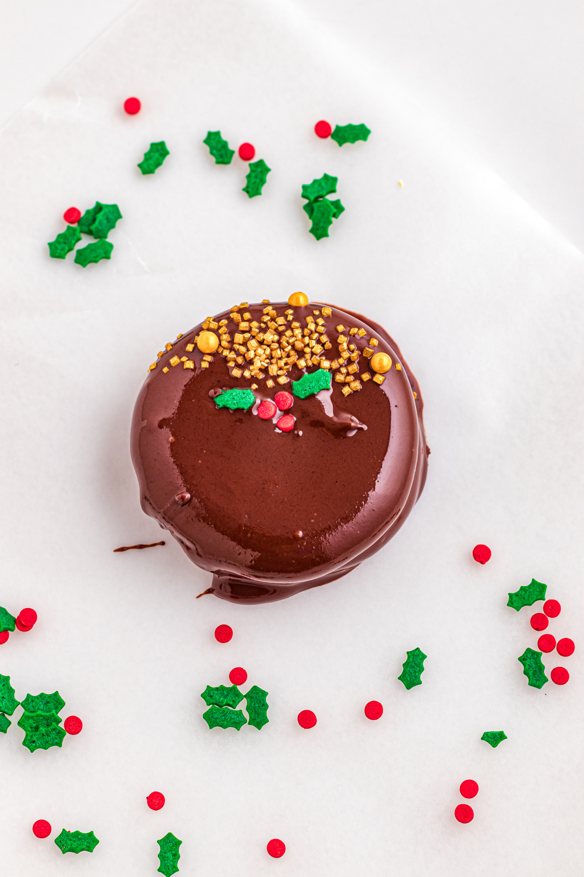 Holly decoration on top of the chocolate cookie.