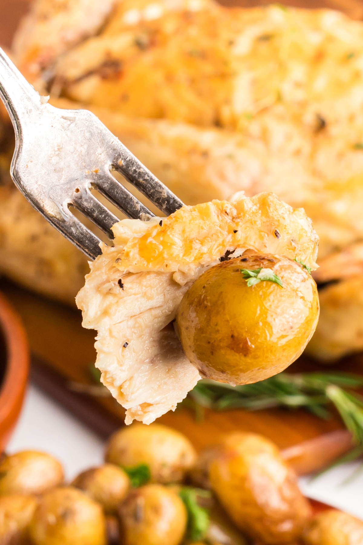 A piece of chicken with a potato on a fork. 