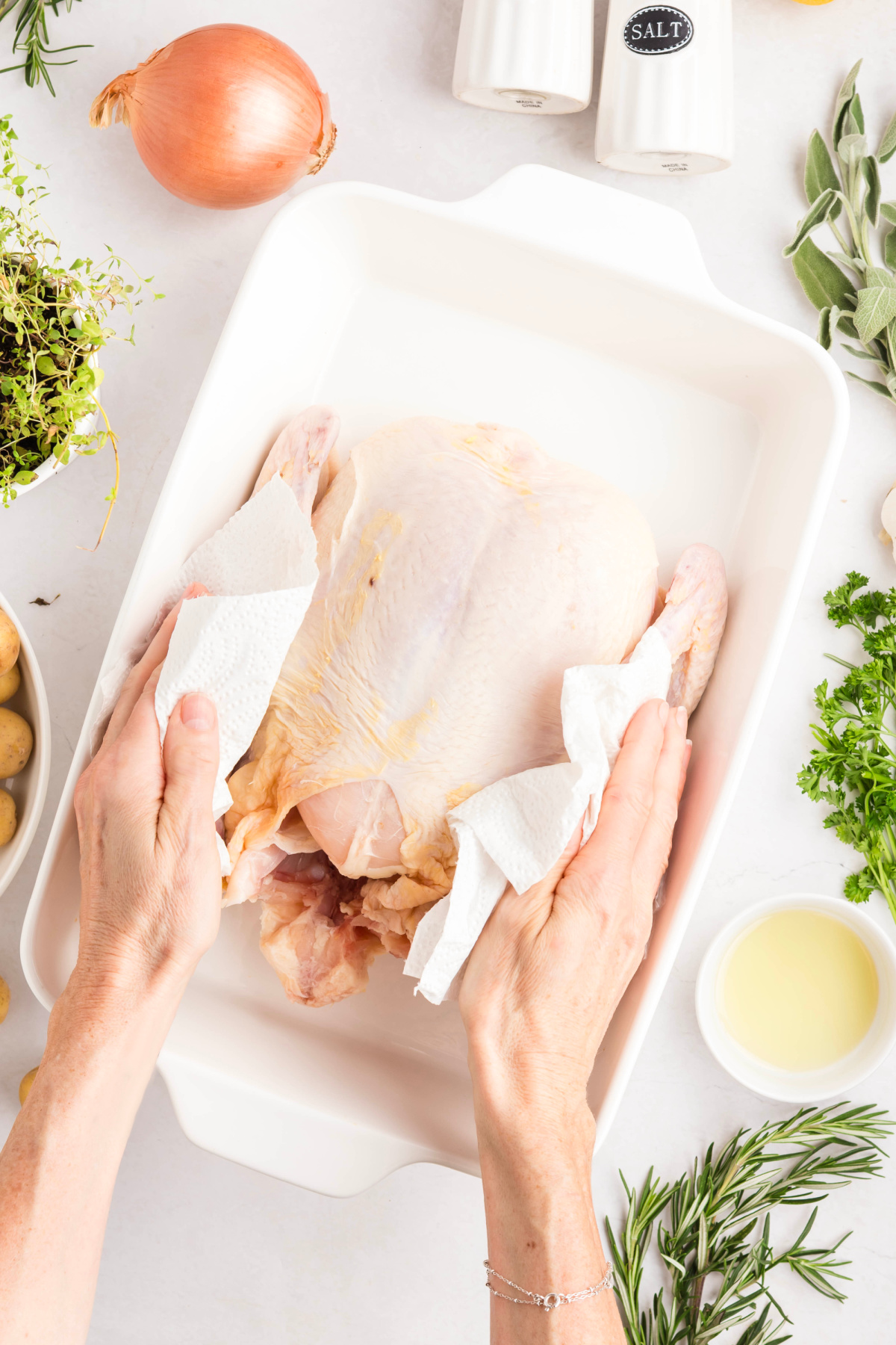Uncooked chicken patted dry with paper towels in a dish.