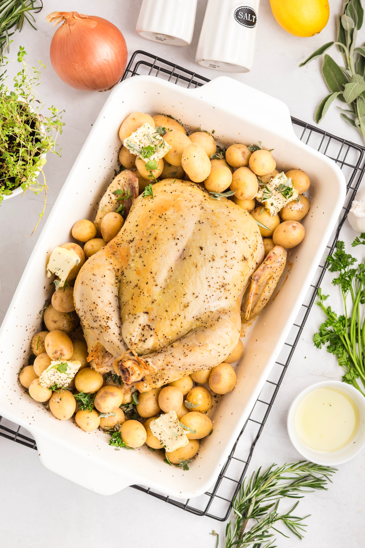 The baby potatoes, butter, and herbs added to the pan.