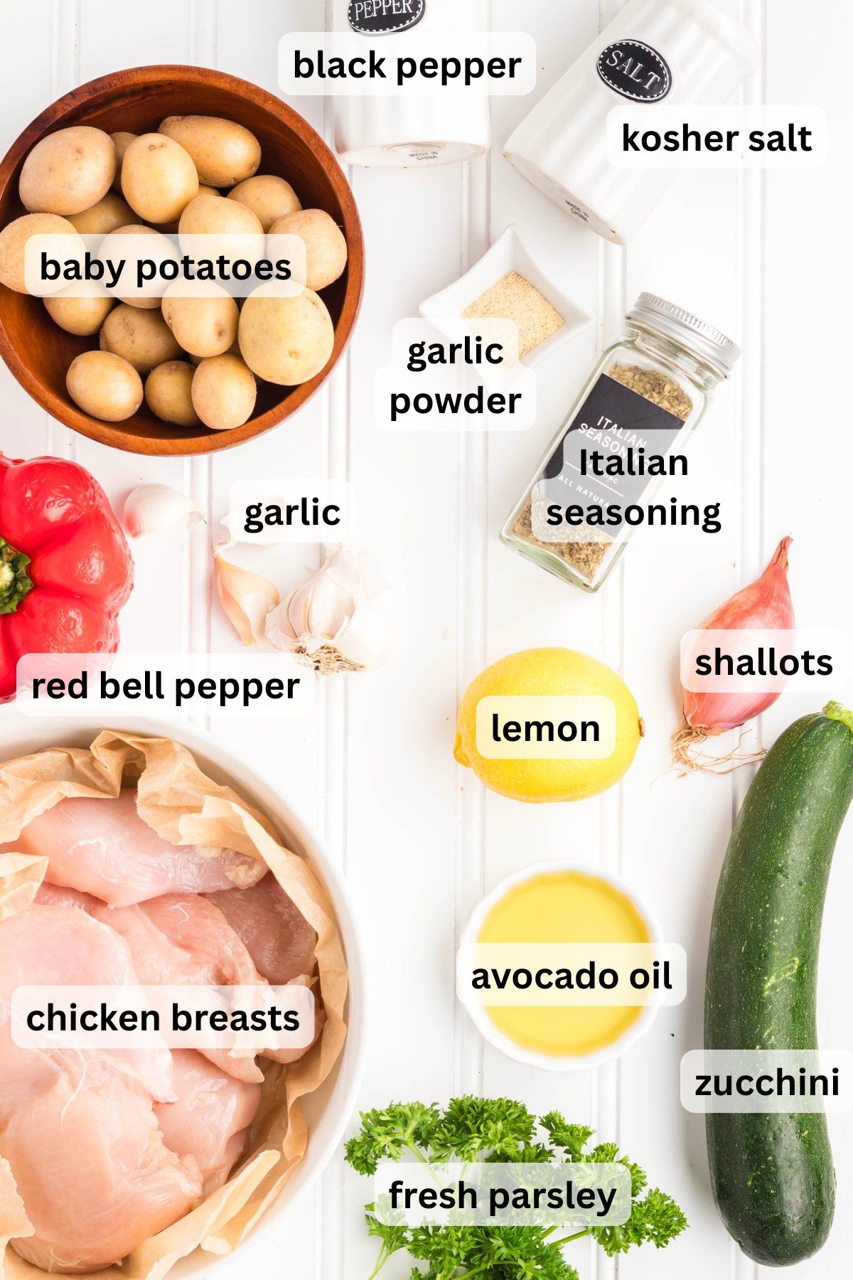 Ingredients to make chicken on a sheet pan on a table.