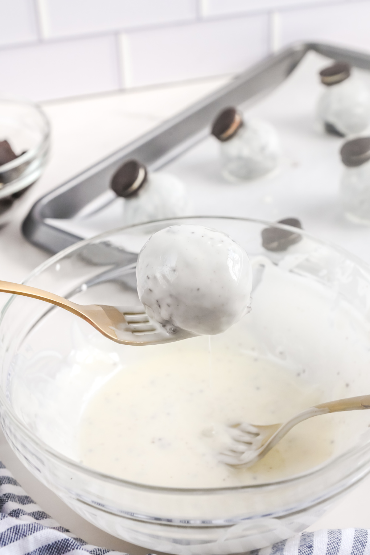 Oreo ball dunked into the white chocolate.