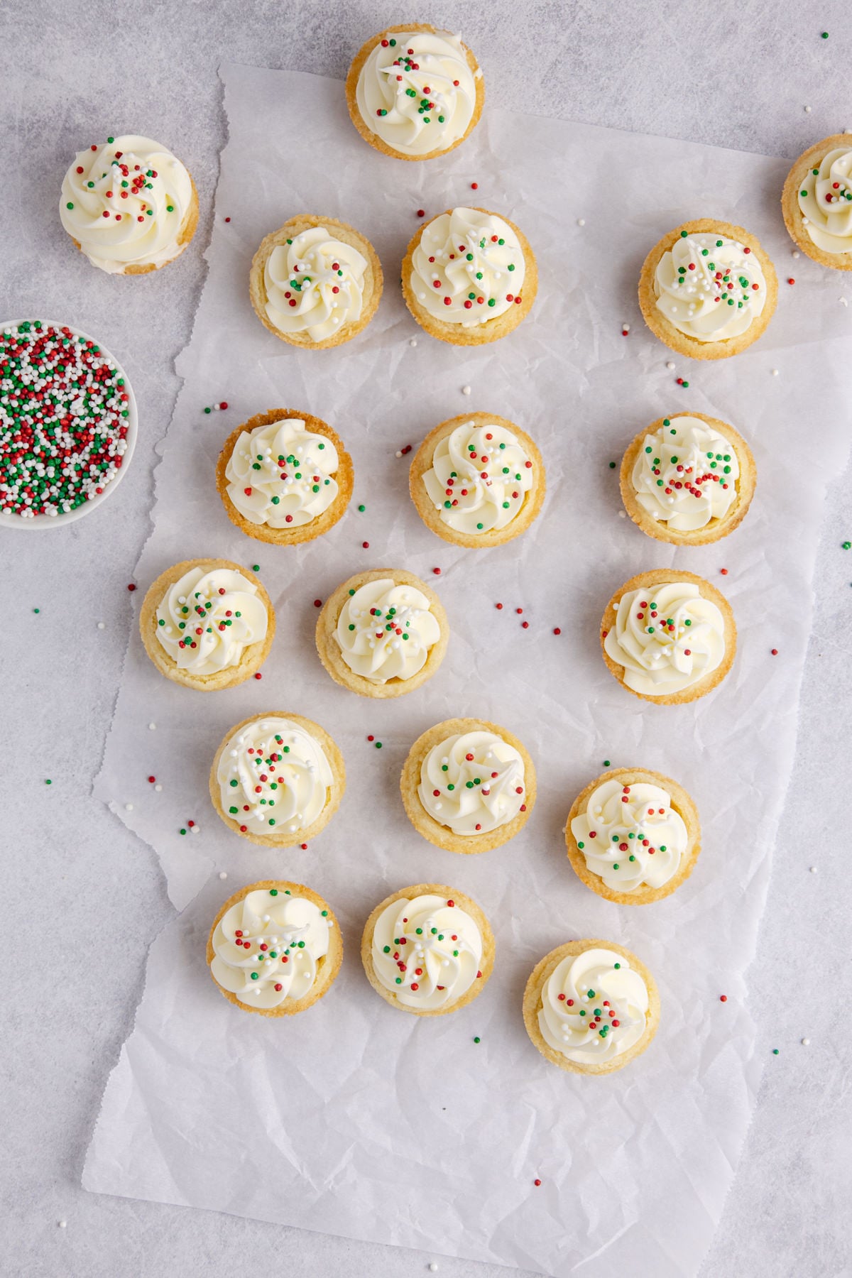 A piping bag filling the cookie cups and sprinkles on top.