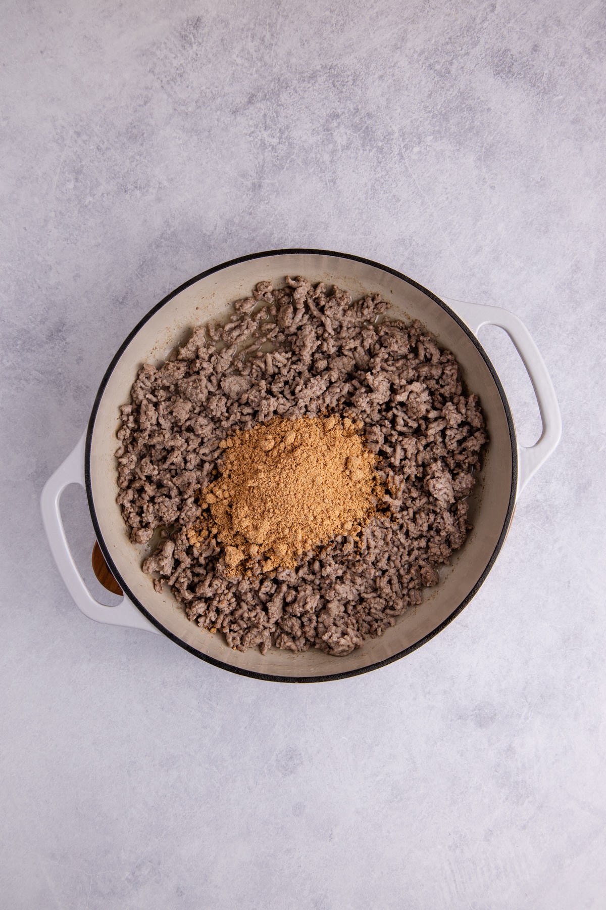 Ground beef and seasoning in a pot.