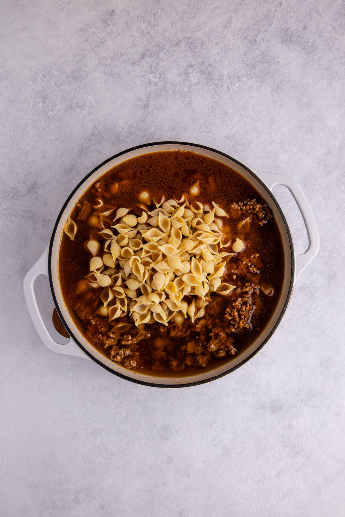 Beef broth and pasta added to the pot.