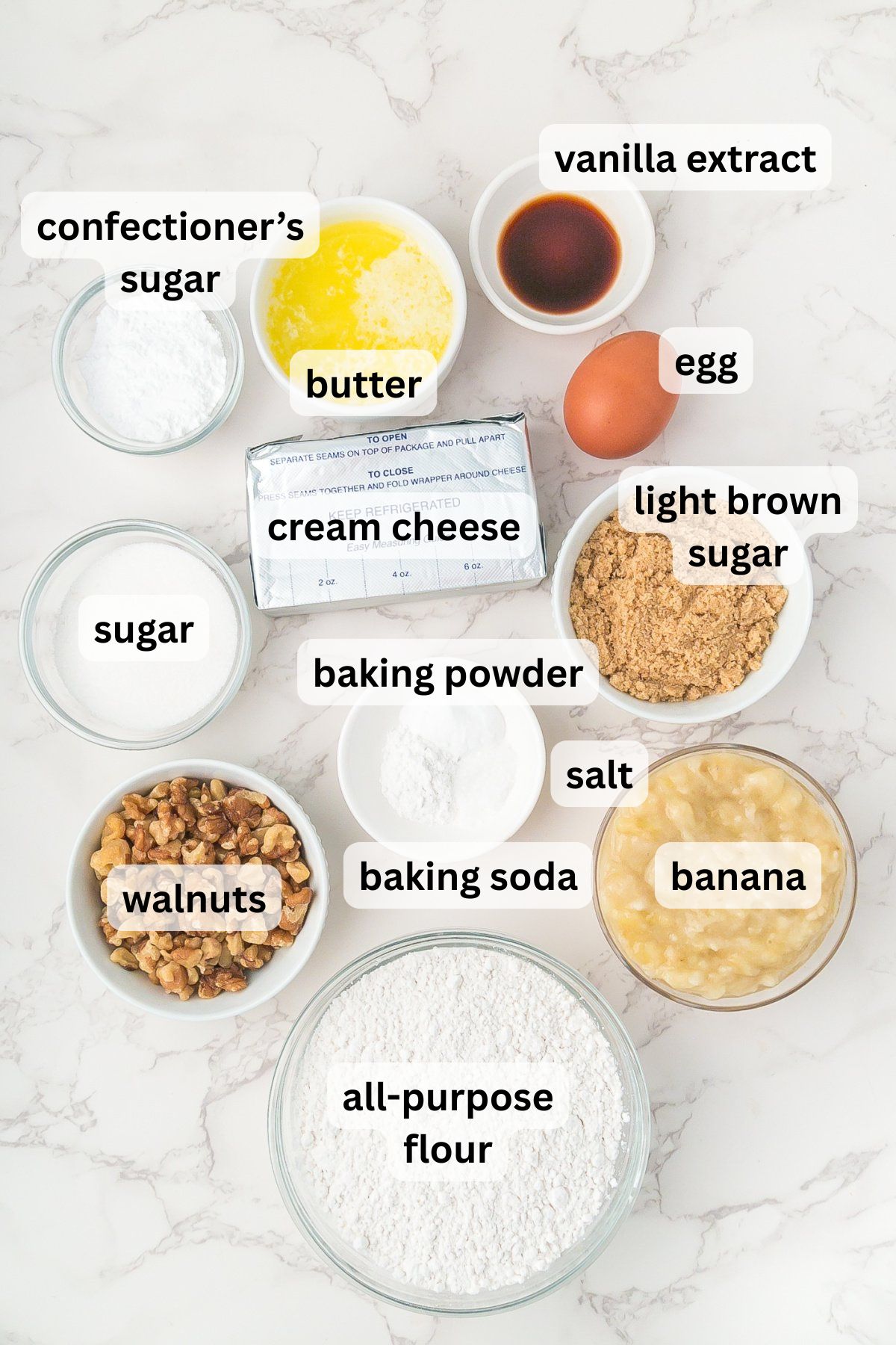 All of the ingredients needed to make Banana Cream Cheese Muffins in bowls on a table.