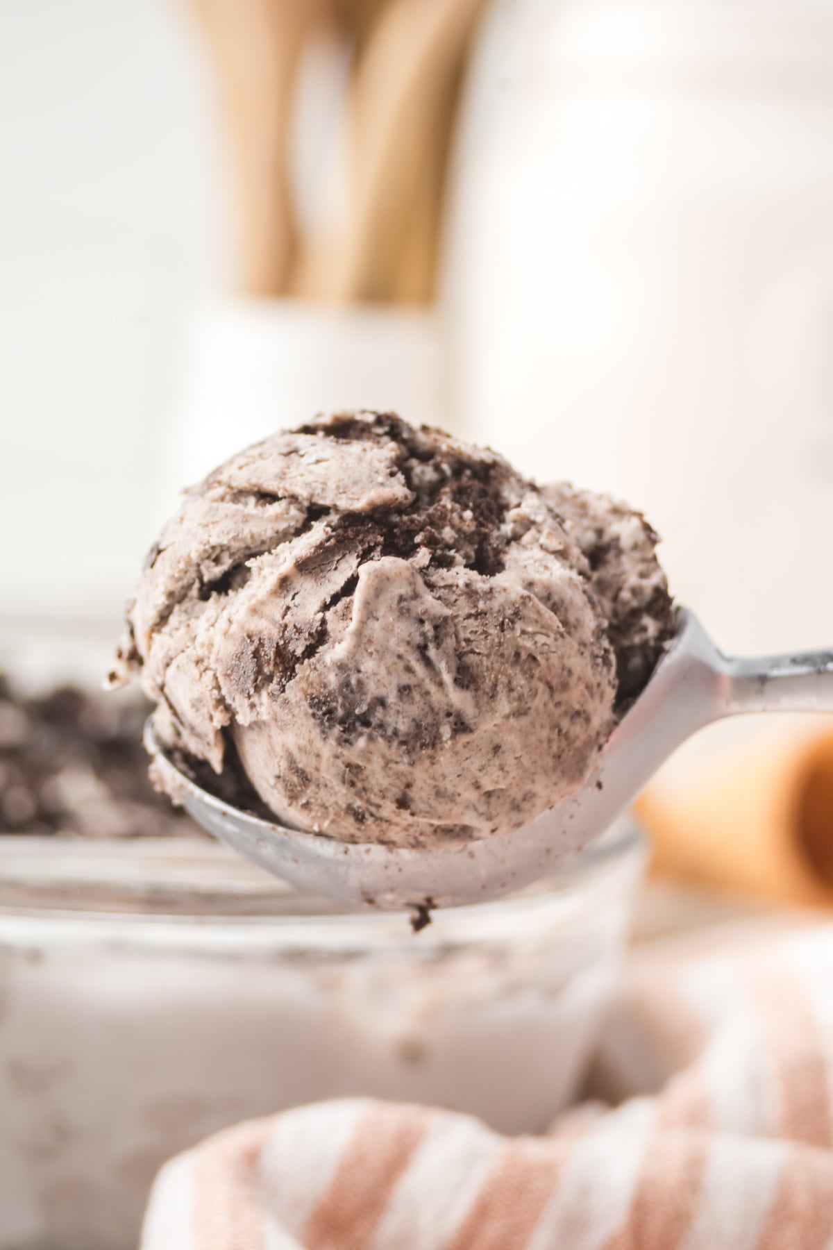 A scoop of Oreo ice cream held in the air.
