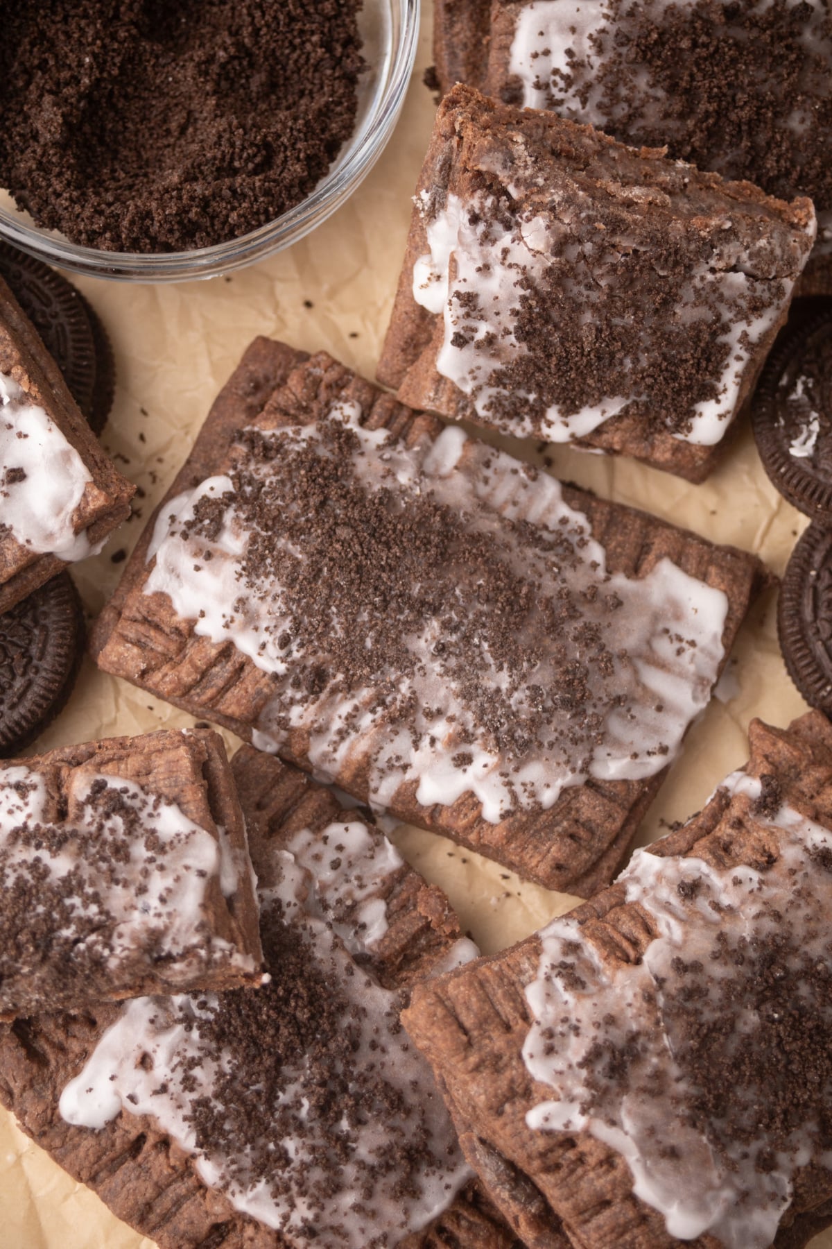 Pop-Tarts scattered on parchment with Oreo cookies.