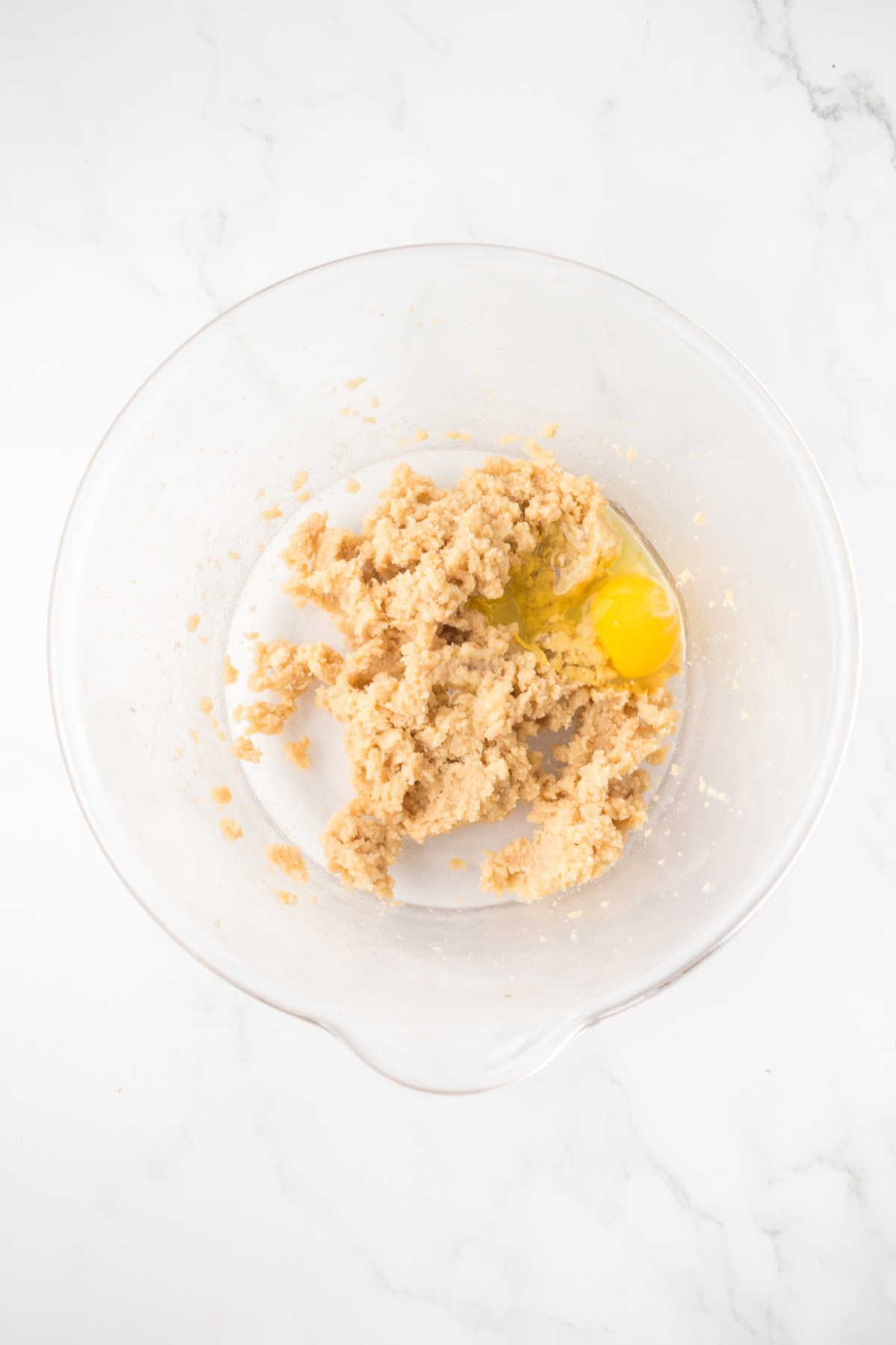 Eggs butter and sugars blended together in a bowl.