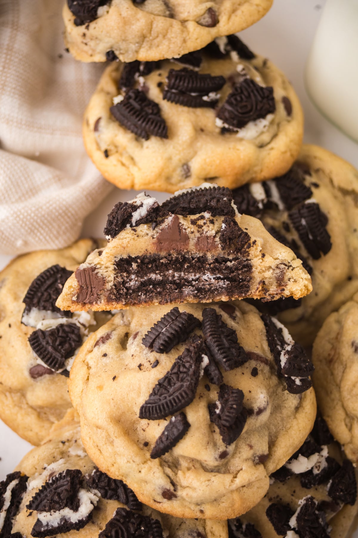 A pile of cookies on a platter with one cut in half on top.