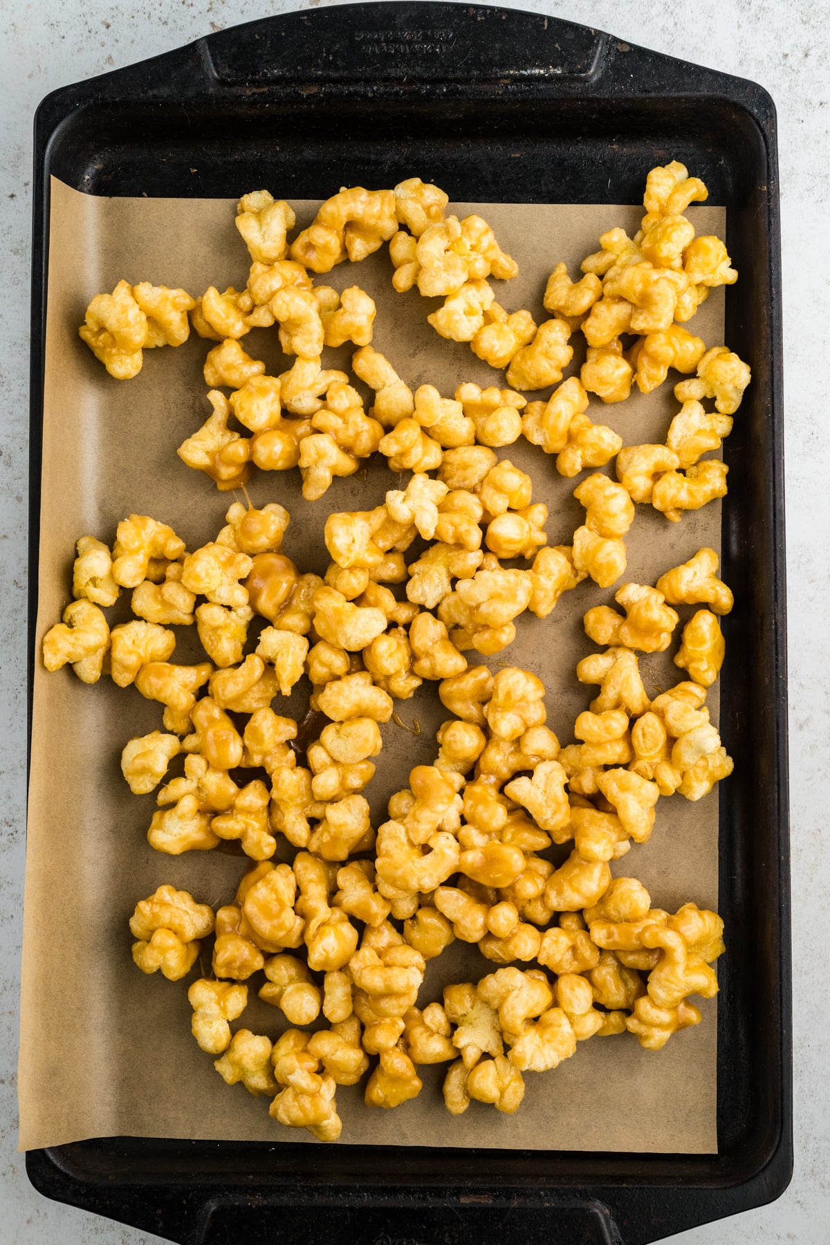 The puffed corn spread on a sheet pan.