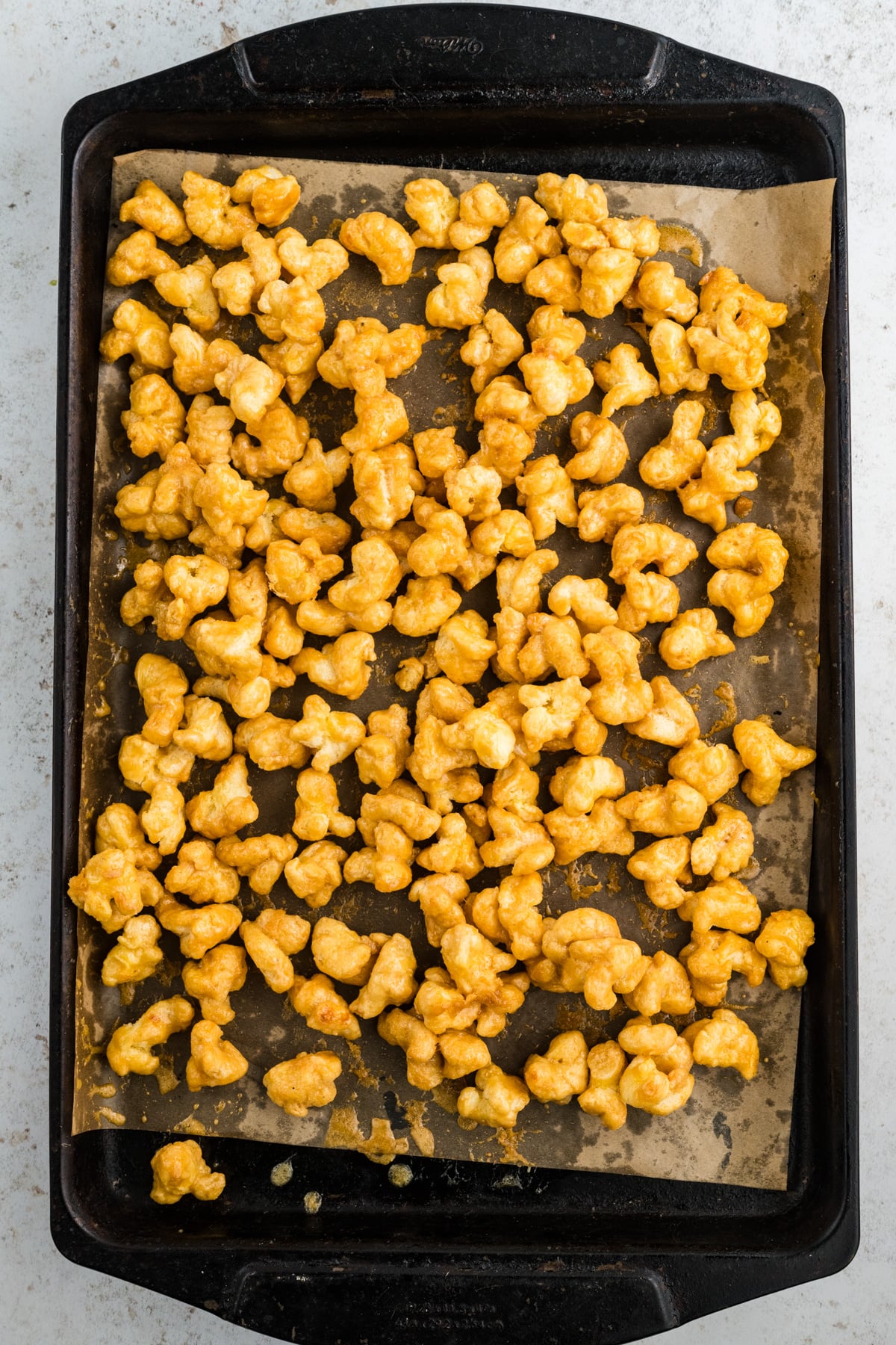 Puffed corn cooked on a sheet pan.