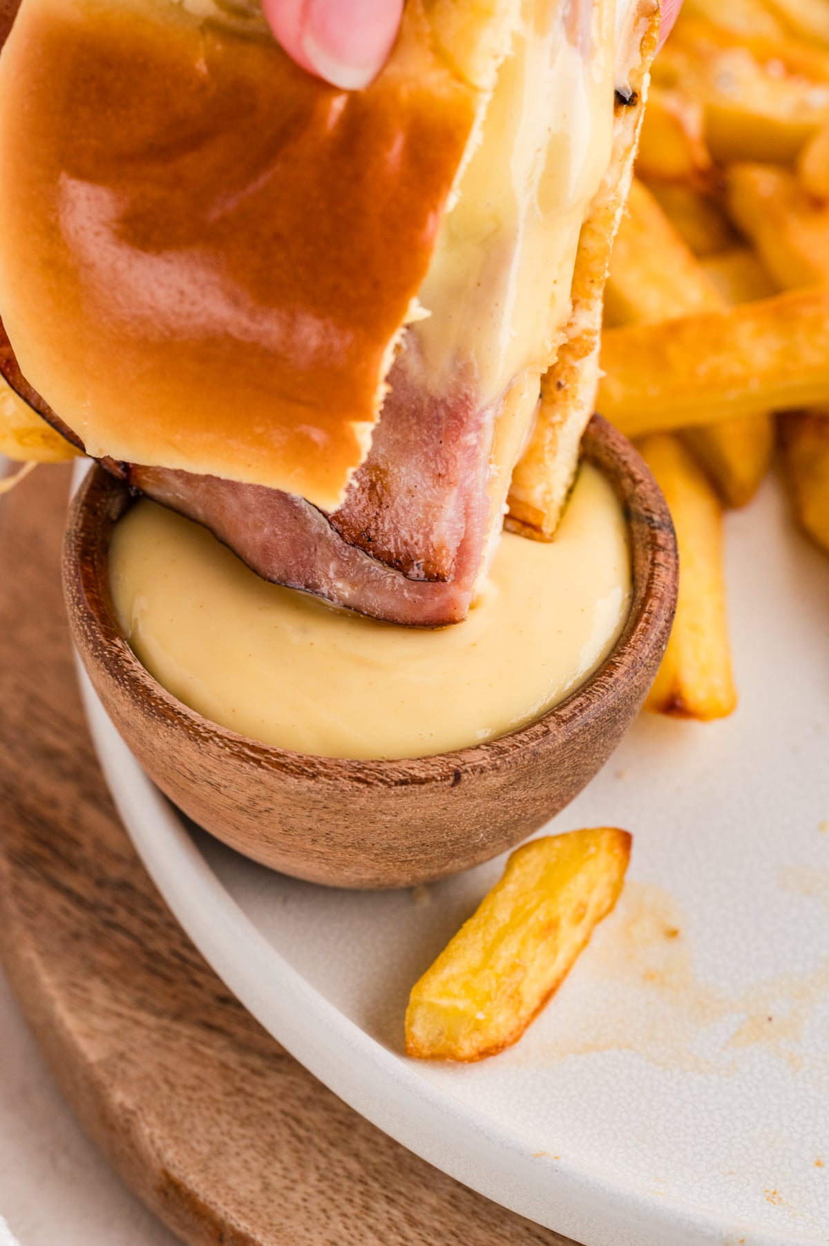 A cordon bleu sandwich being dipped into a sauce.
