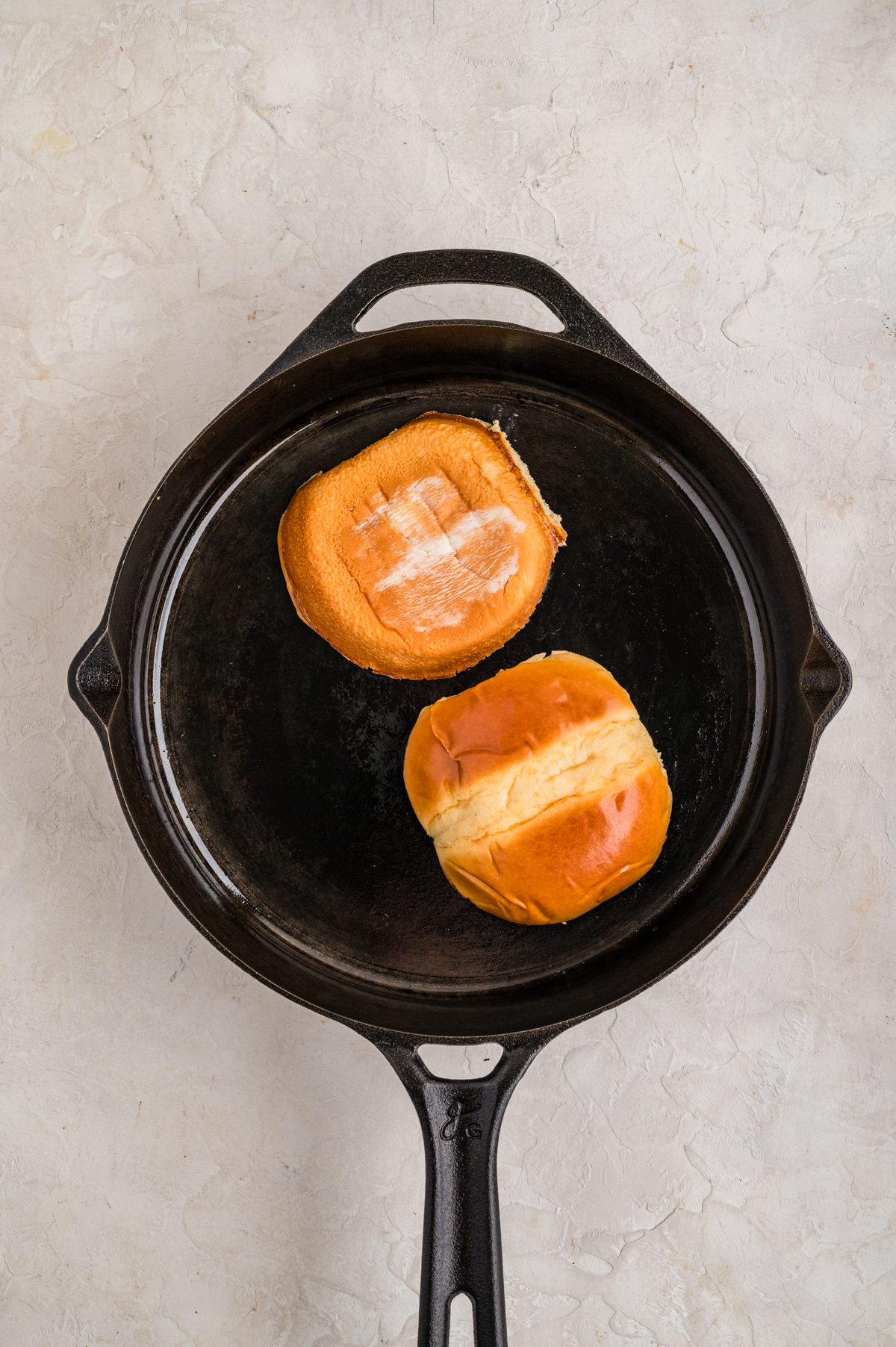 A bun toasting on a skillet.