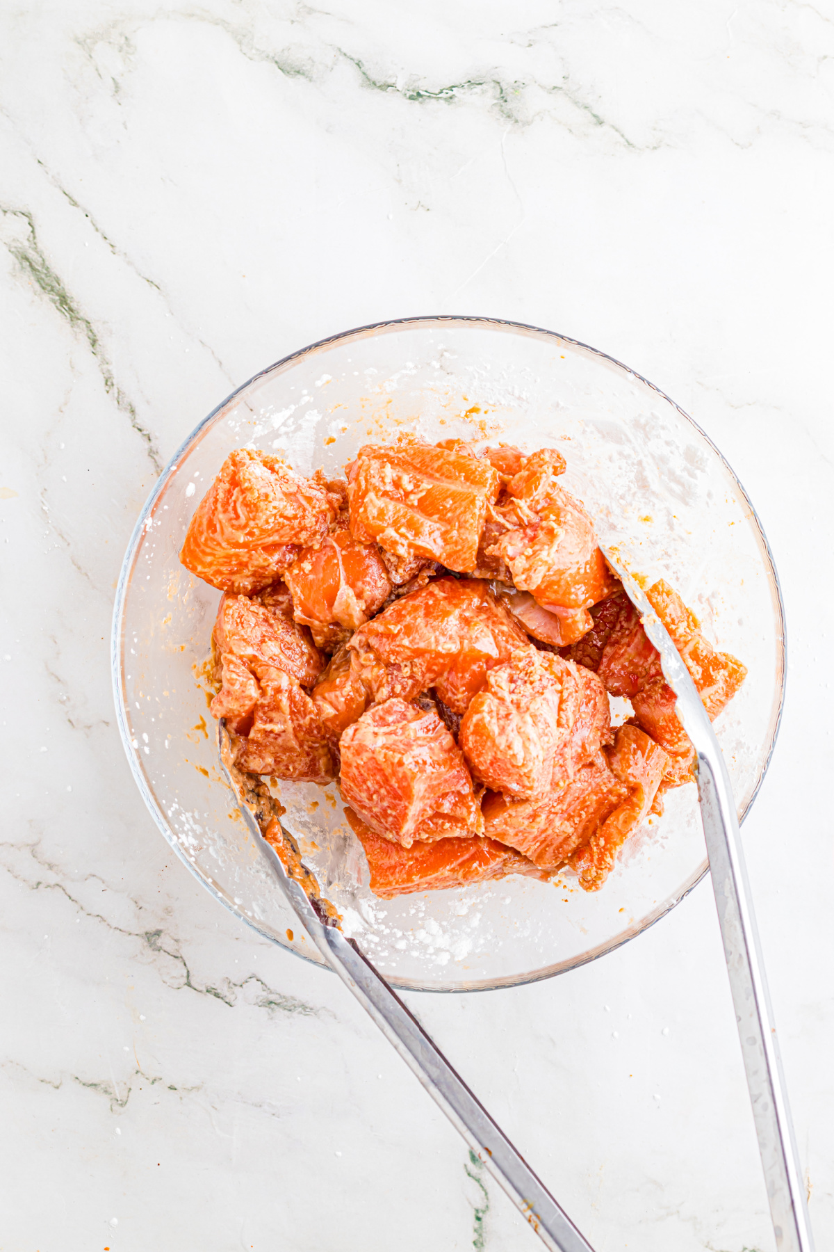 Salmon pieces in a bowl with marinade.