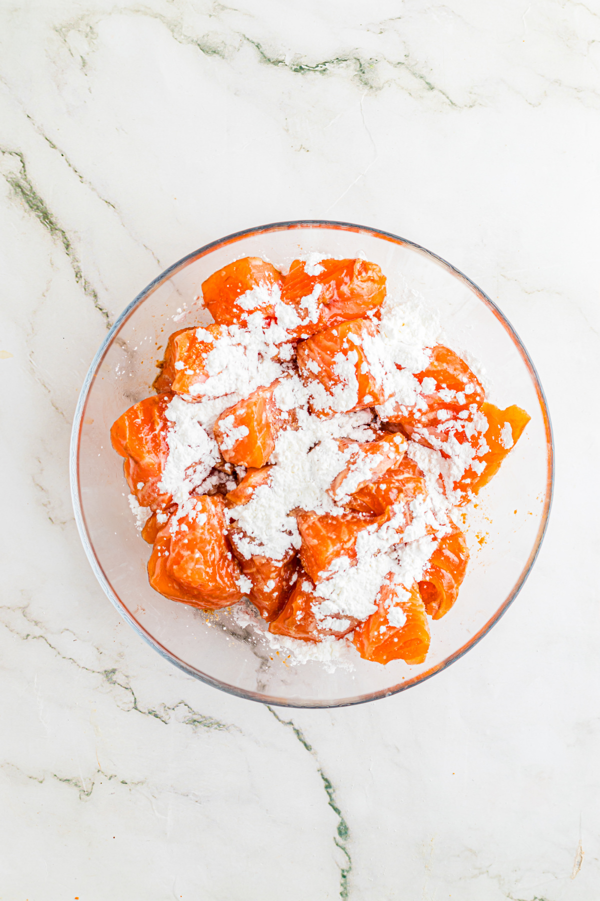 Salmon pieces with cornstarch on top.