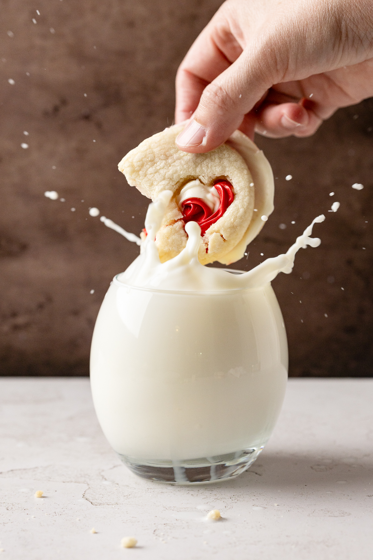 A cookie being dunked into milk.