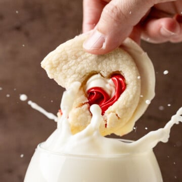 Cookie being dunked in a glass of milk