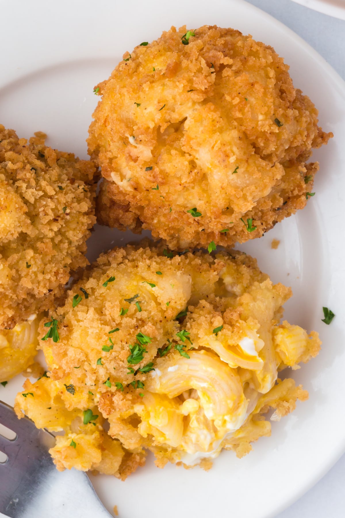 A few mac and cheese balls on a plate.