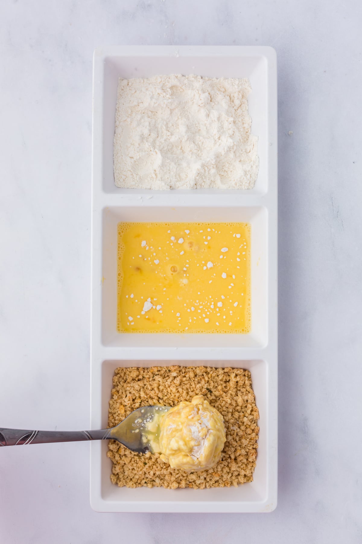 Each ball rolled in flour, then egg and water.