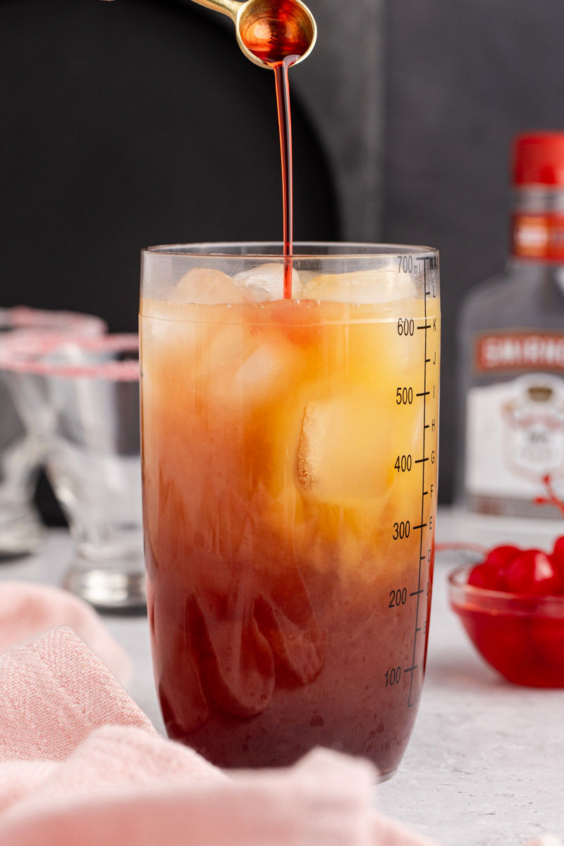 Cocktail ingredients and ice added into a shaker to chill.