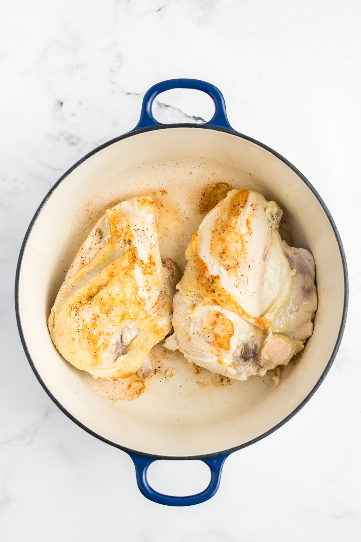 Chicken breast searing in a dutch oven.
