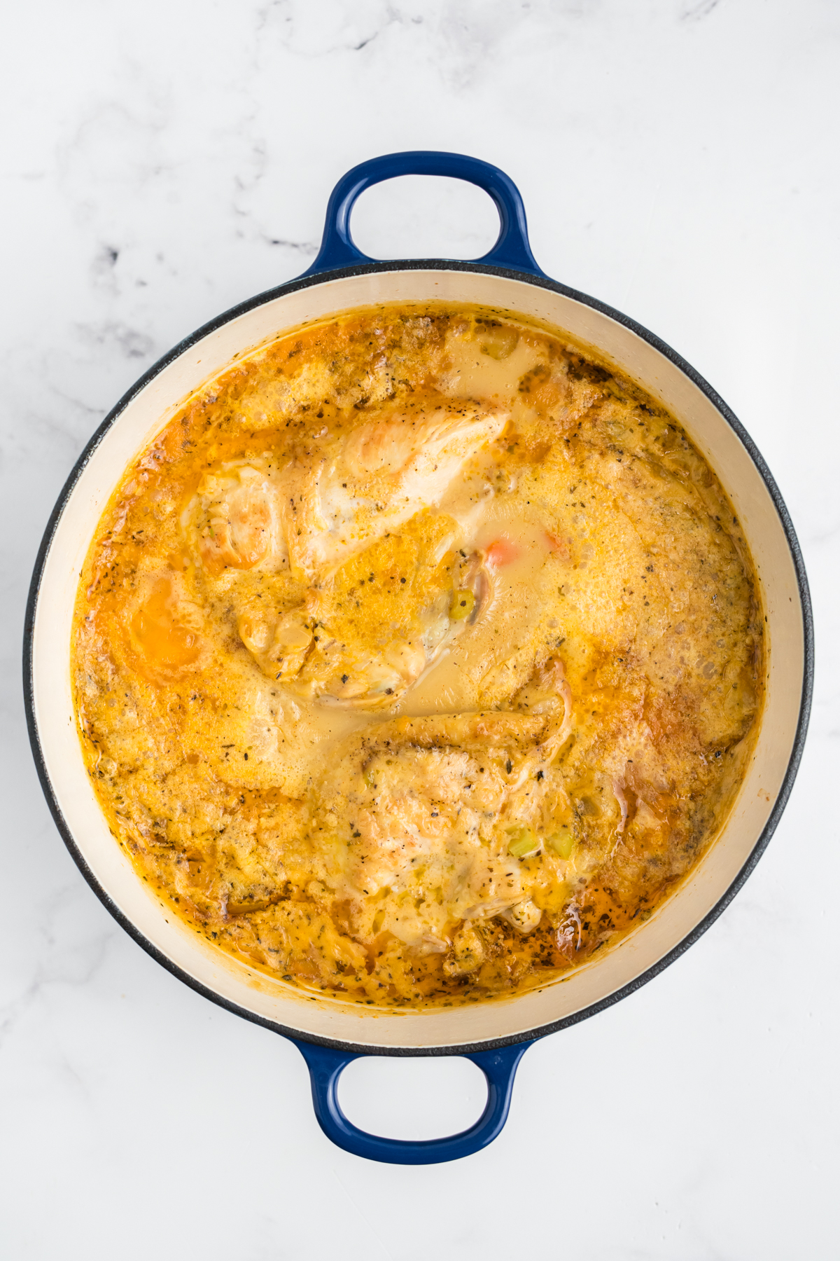 Chicken being shredded, and potatoes added to the stew.