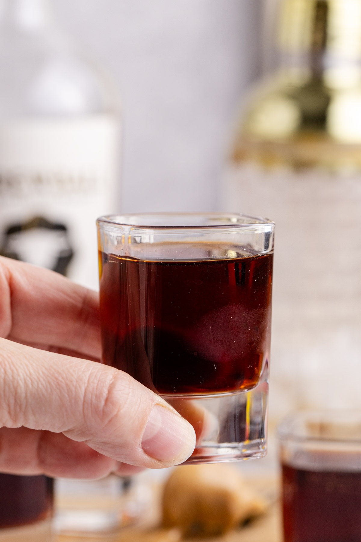 Peanut Butter Shot is held in the air ready to drink.