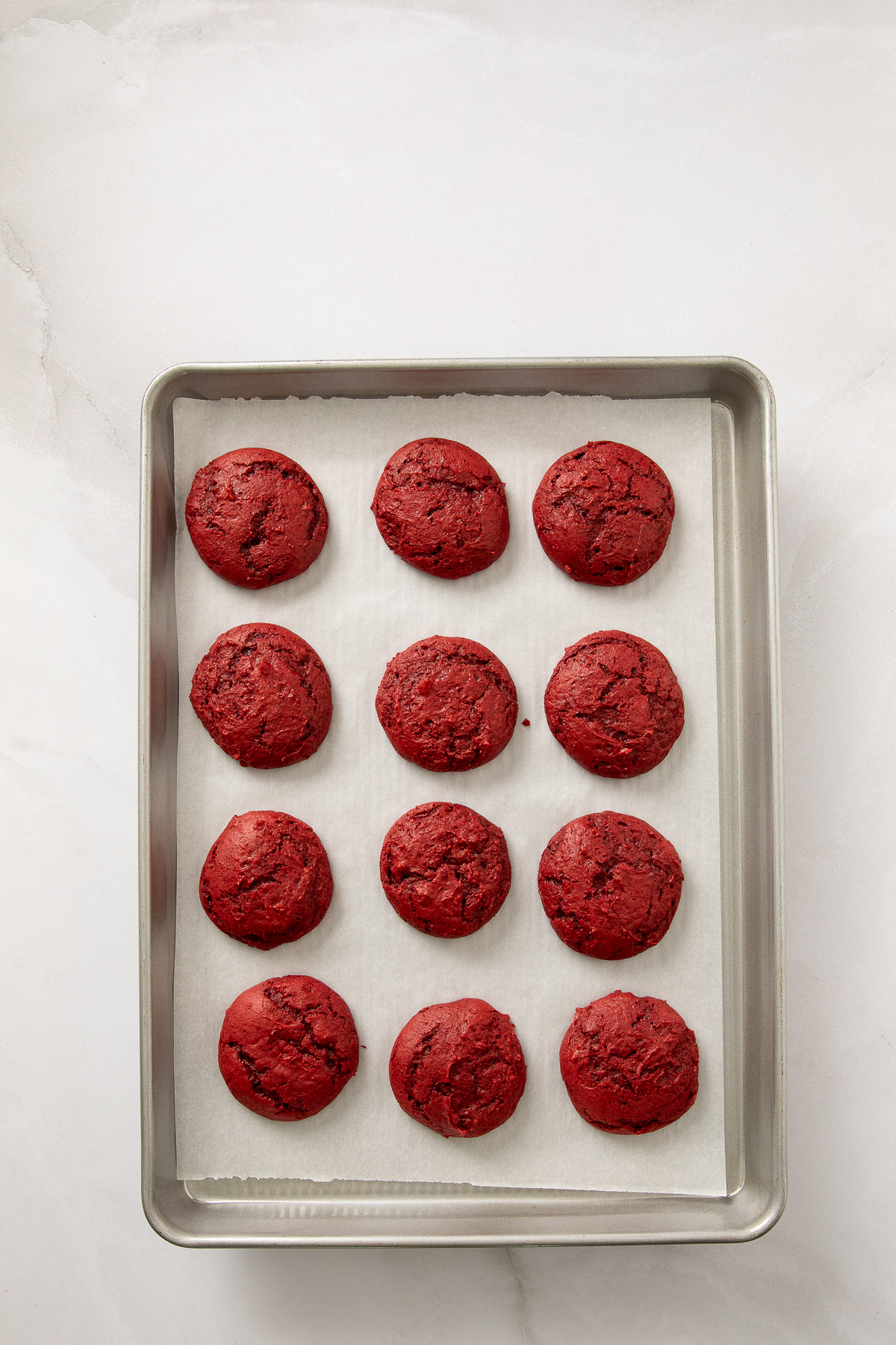 Baked cookies cooling on a sheet pan.