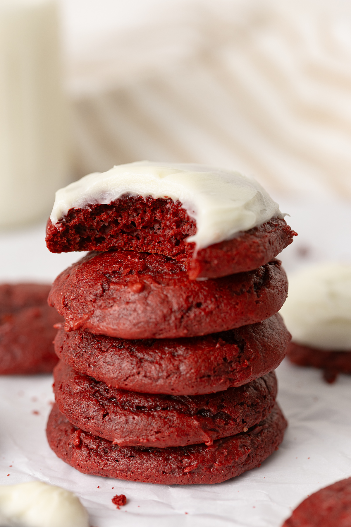 A bitten cookie on top of a stack of cookies.