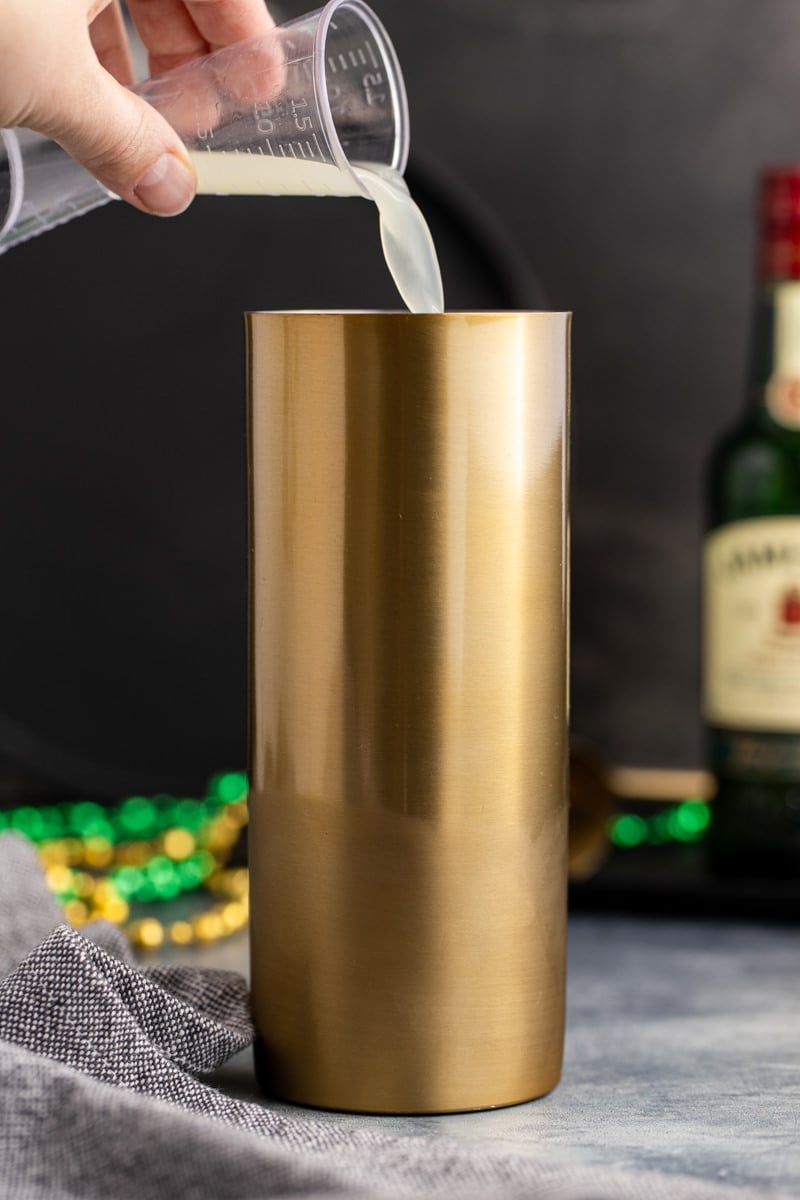 Whisky ingredients poured into a shaker.