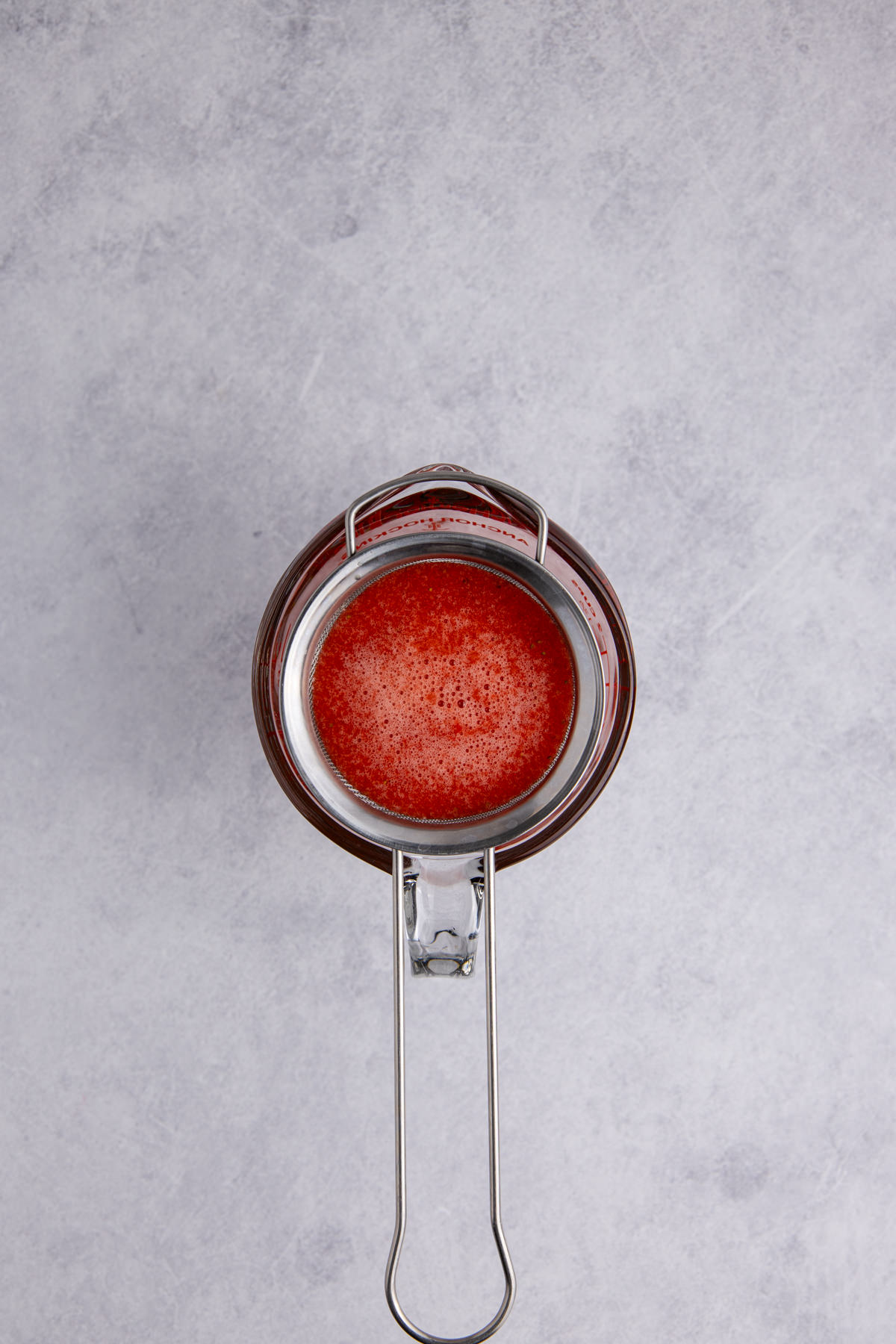 A strainer removing the pulp and seeds.