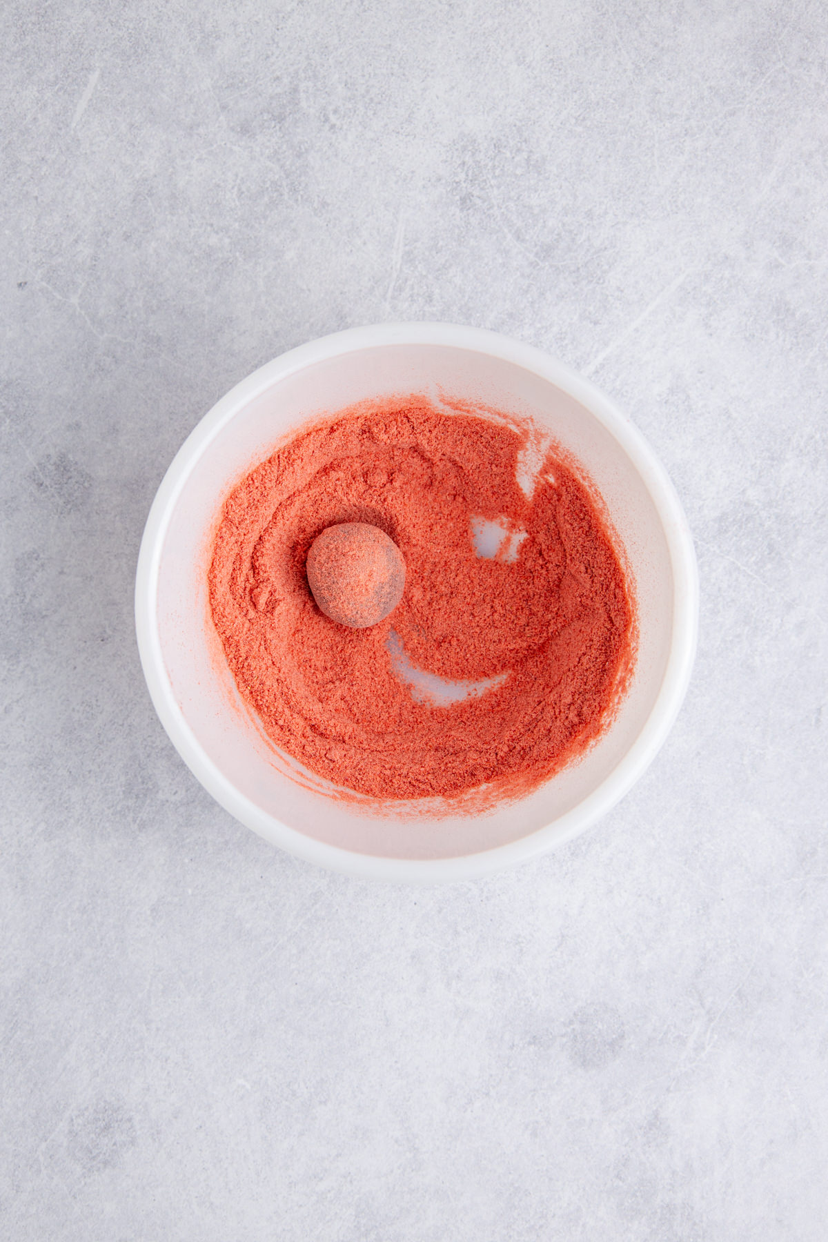 The truffles rolled into the strawberry powder.