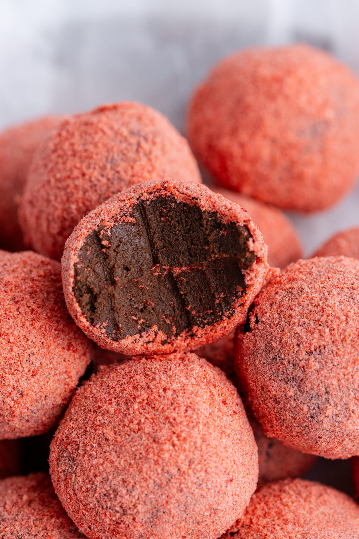 A truffle that is half eaten stacked on other truffles.