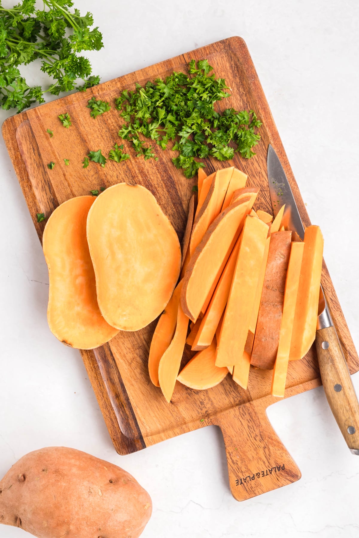 Sweet potatoes cut up on a cutting board.