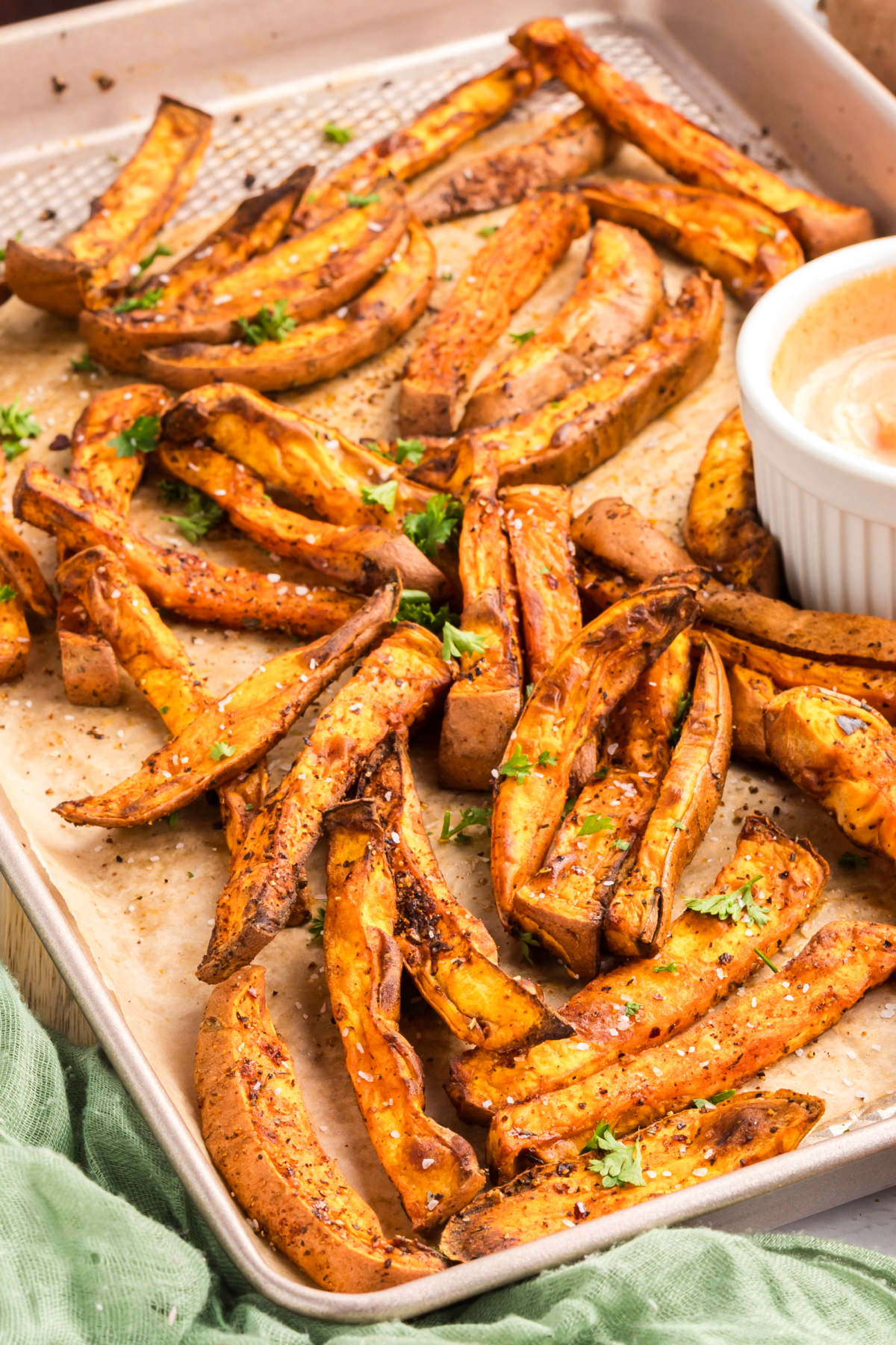 Sweet potato on a sheet pan with a parsley garnish.