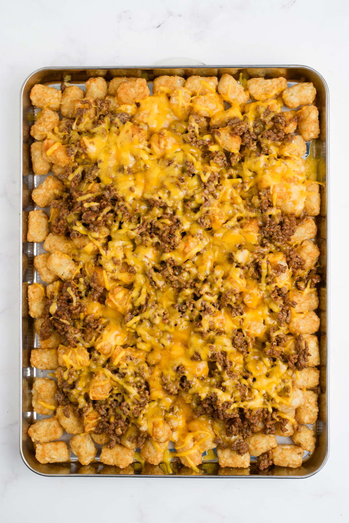 Cheese melted over the top of the tater tots.