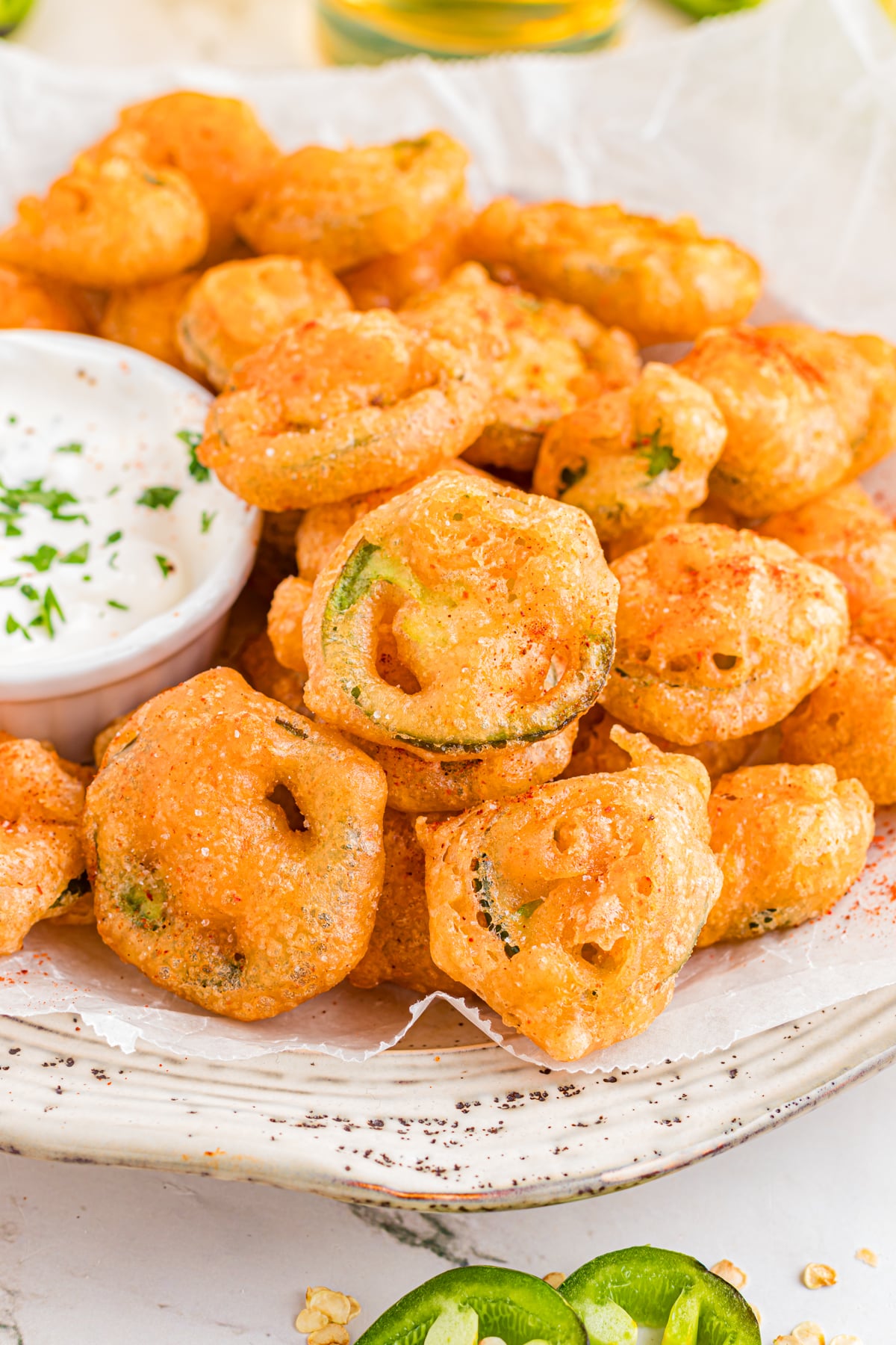 A plate filled with fried jalapenos.