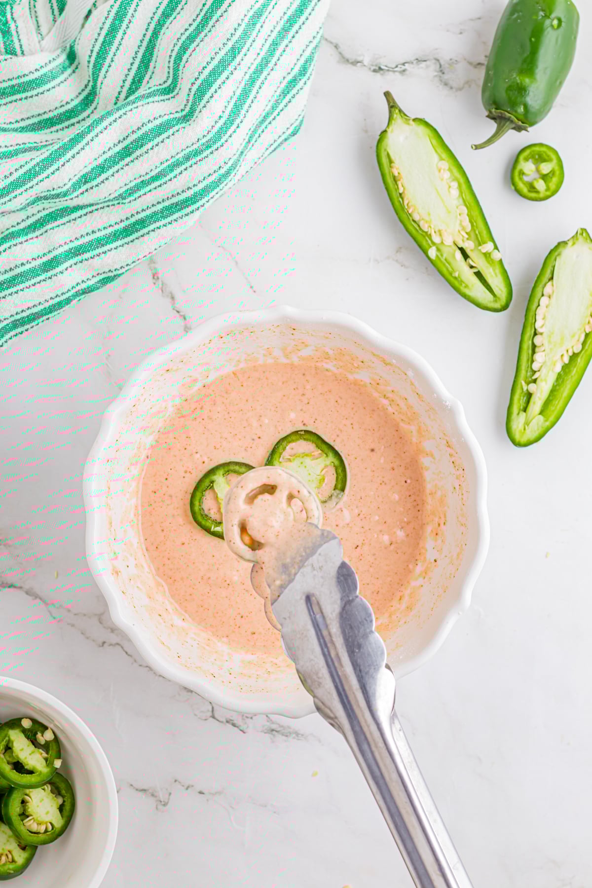 Dipping the jalapeno slices into the beer batter.