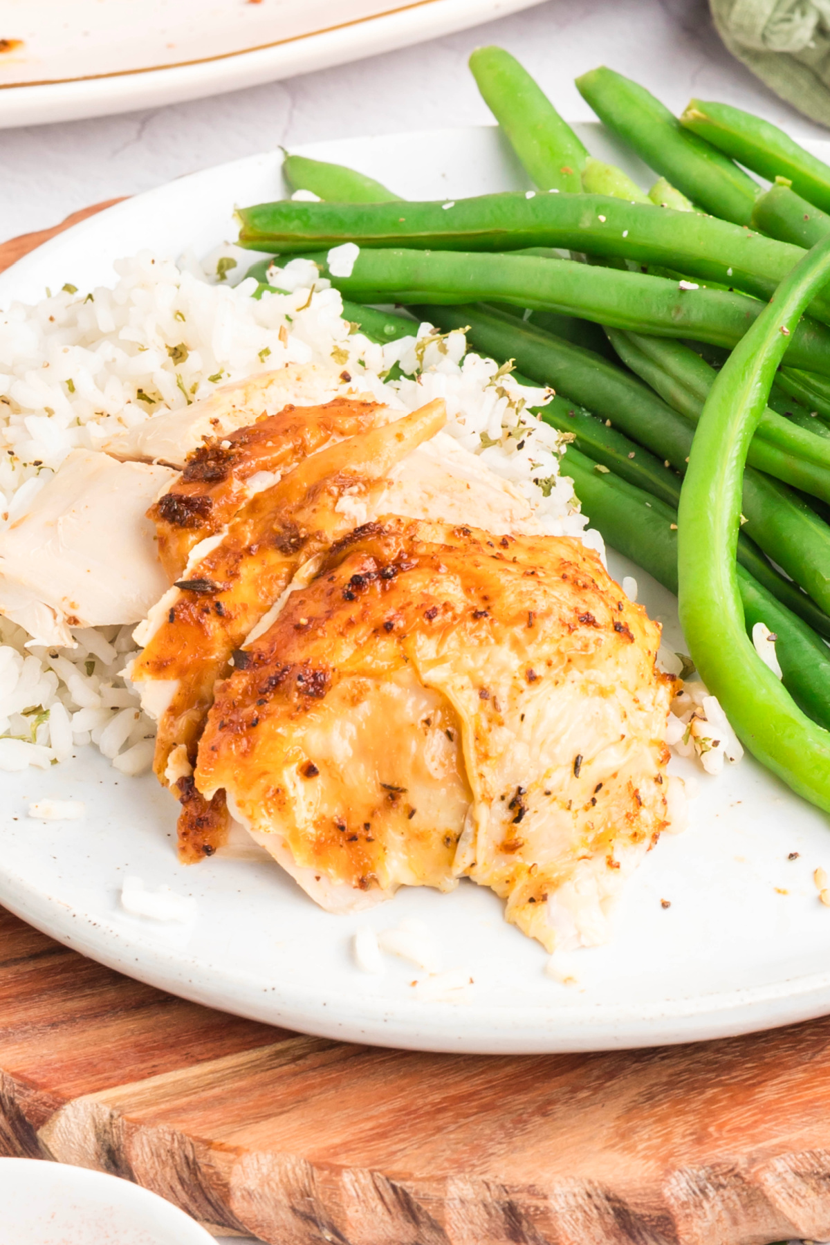 Slices of air fryer rotisserie chicken over a bed of rice.