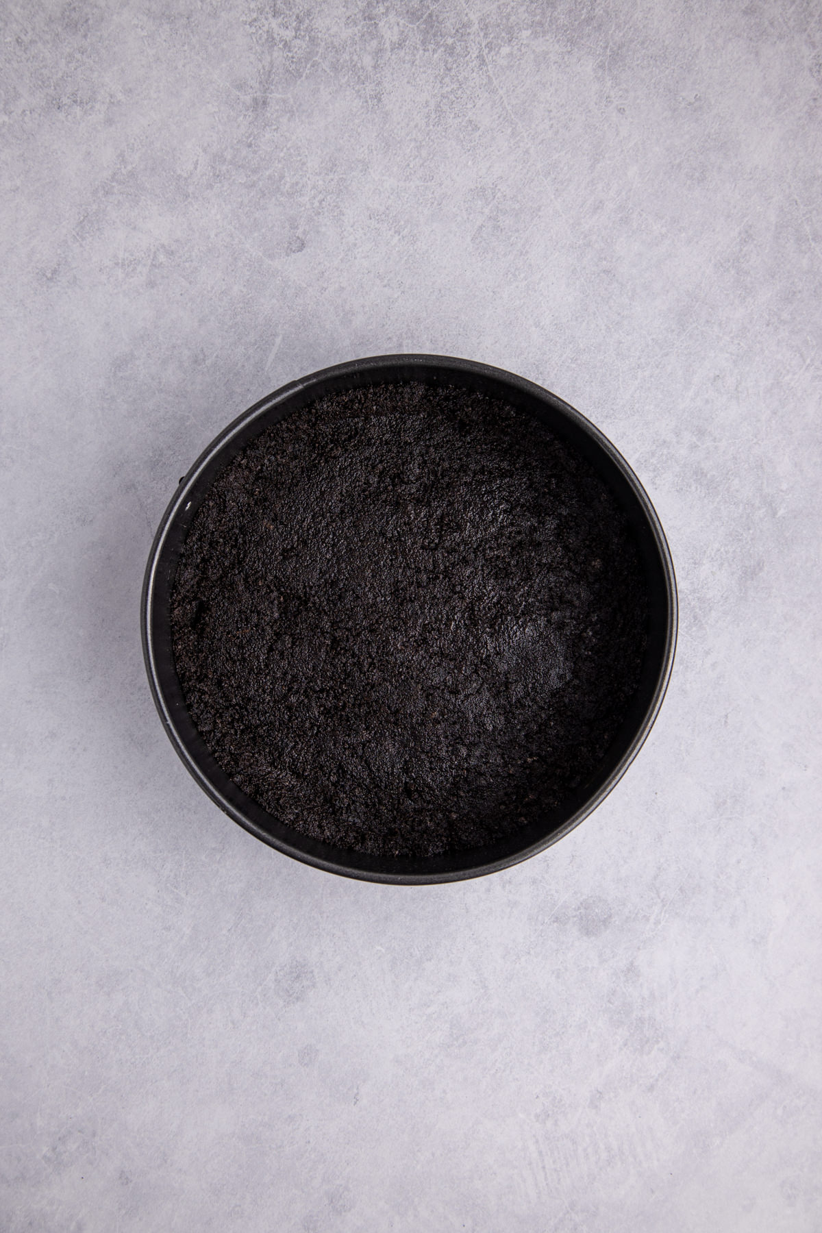 Crushed Oreos and melted butter combined and pressed into the bottom of the springform pan.