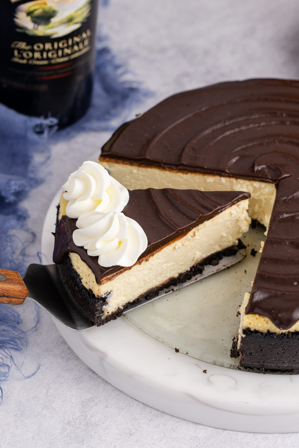 A slice of Bailey's cheesecake with chocolate on top being lifted.